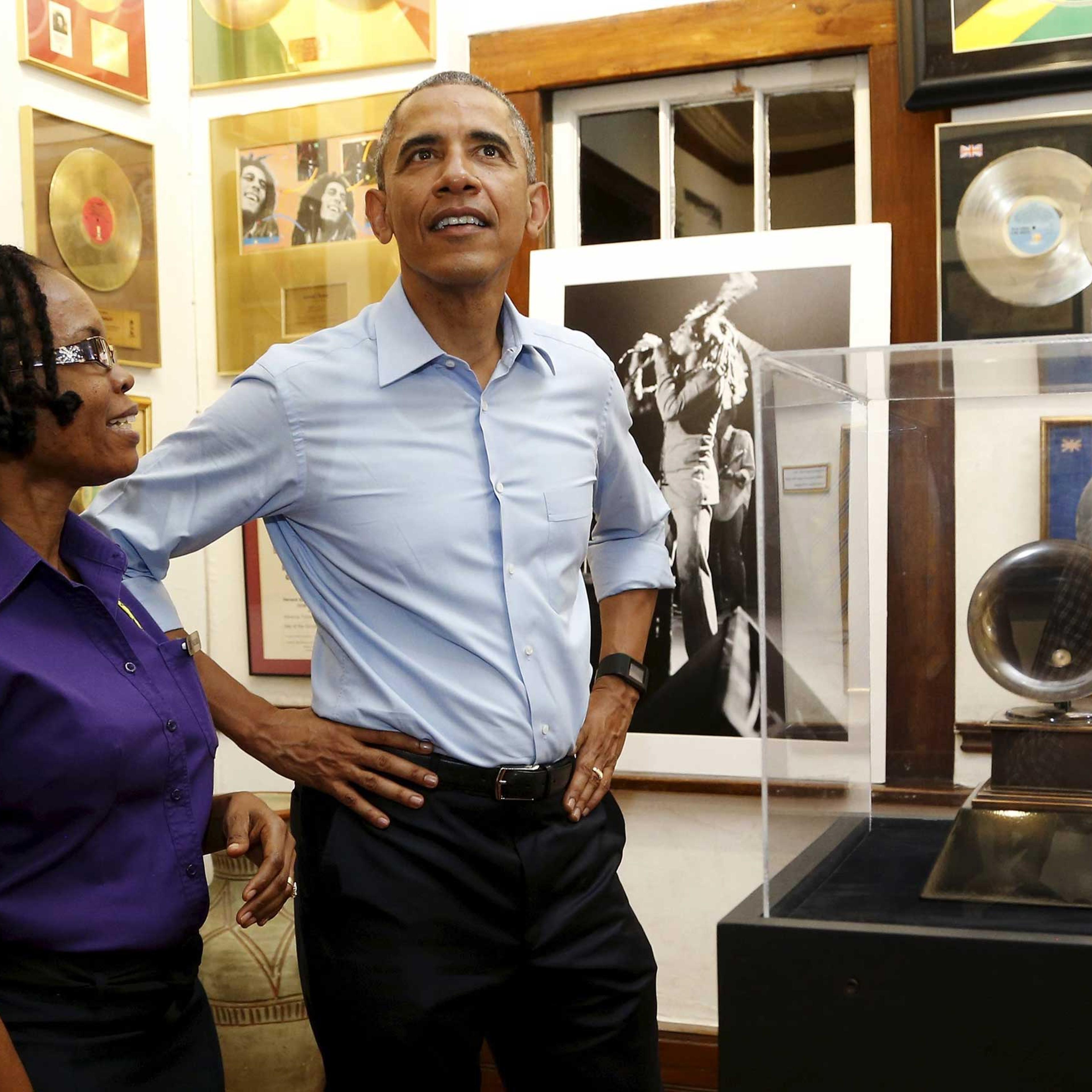 U.S. President Barack Obama gets a tour of the Bob Marley Museum from staff member Natasha Clark (L) in Kingston, Jamaica on April 8, 2015.