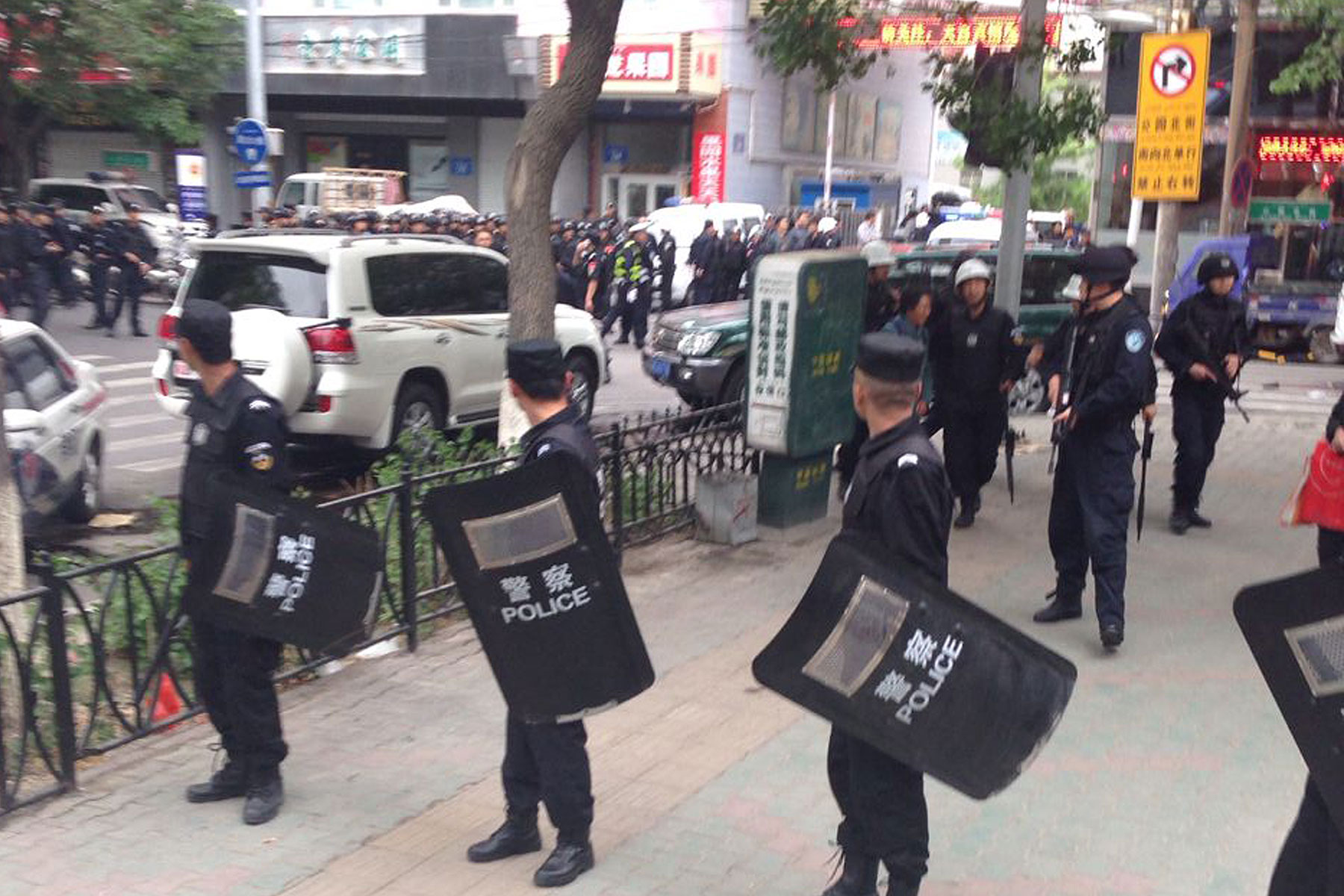In this photo released by China's Xinhua News Agency, police officers stand guard near a blast site which has been cordoned off, in downtown Urumqi, capital of northwest China's Xinjiang Uygur Autonomous Region, May 22, 2014