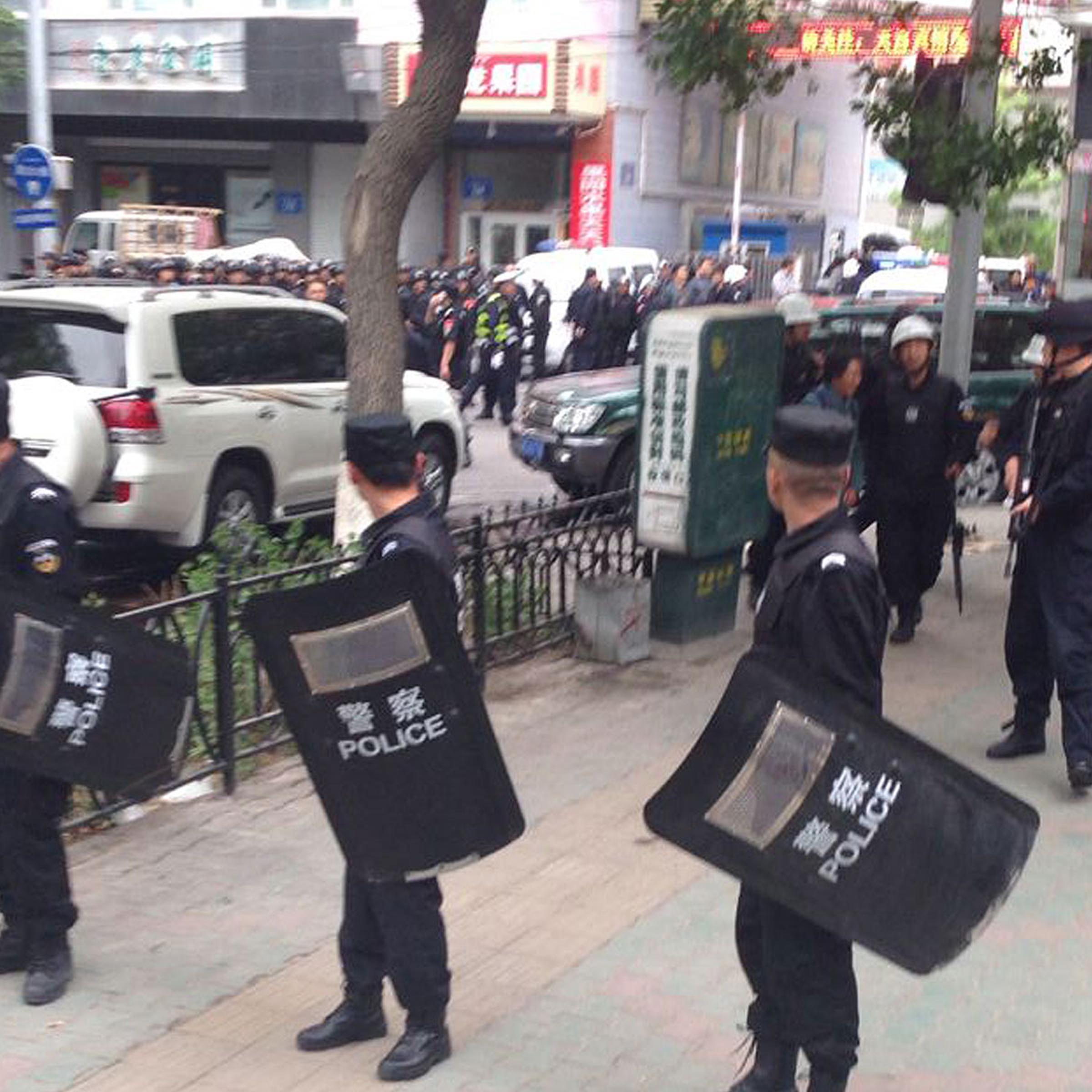 In this photo released by China's Xinhua News Agency, police officers stand guard near a blast site which has been cordoned off, in downtown Urumqi, capital of northwest China's Xinjiang Uygur Autonomous Region, May 22, 2014