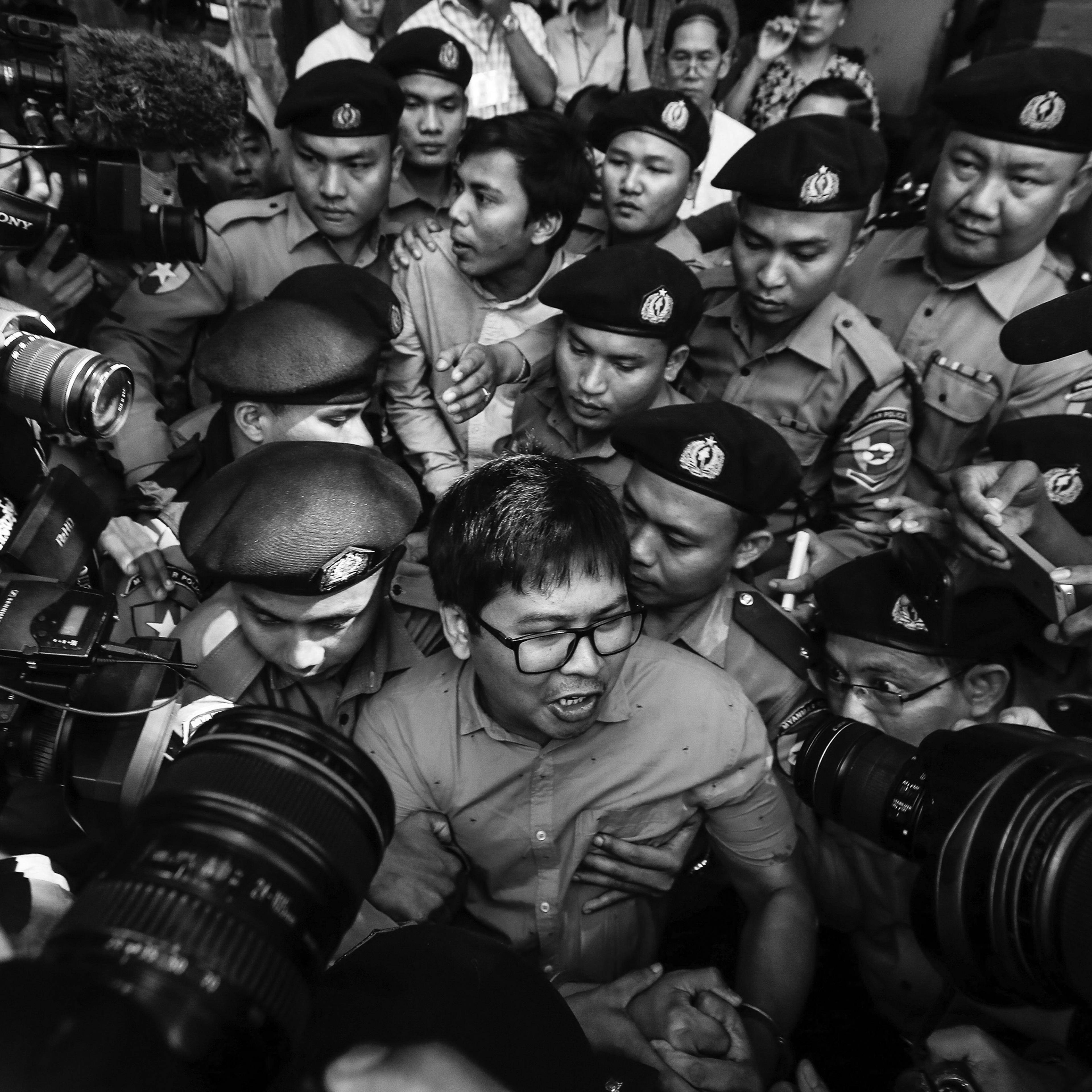 Reuters' journalists Wa Lone (C, front) and Kyaw Soe Oo (C, back) are escorted by police as they leave the court after their first trial in Yangon, Myanmar, 10 January 2018. Reuters journalists Wa Lone and Kyaw Soe Oo were arrested on the outskirts of Yangon city on 12 December 2017 by Myanmar police for allegedly possessing classified police documents. In September the journalists were convicted to seven years in prison.