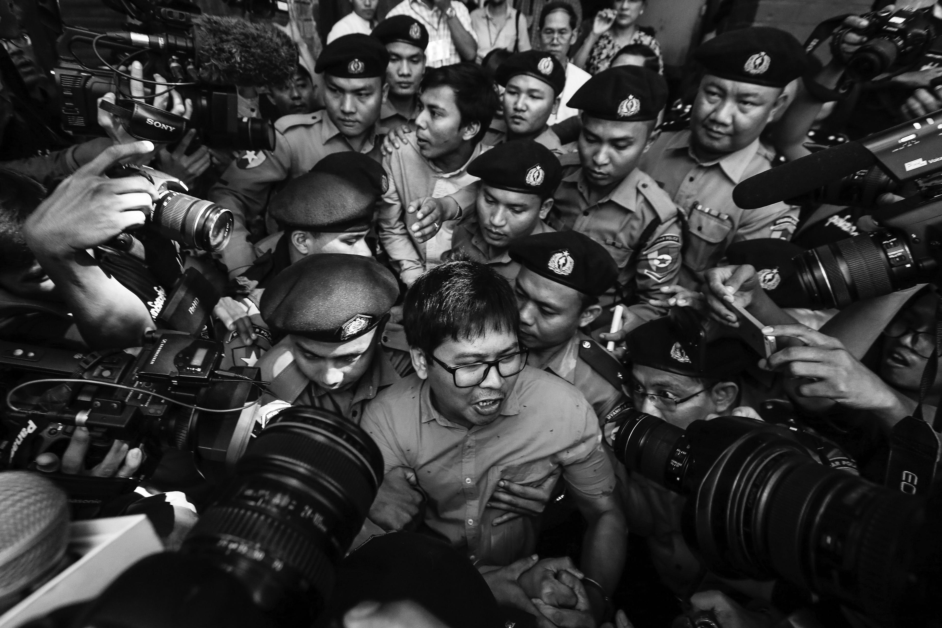 Reuters' journalists Wa Lone (C, front) and Kyaw Soe Oo (C, back) are escorted by police as they leave the court after their first trial in Yangon, Myanmar, 10 January 2018. Reuters journalists Wa Lone and Kyaw Soe Oo were arrested on the outskirts of Yangon city on 12 December 2017 by Myanmar police for allegedly possessing classified police documents. In September the journalists were convicted to seven years in prison.