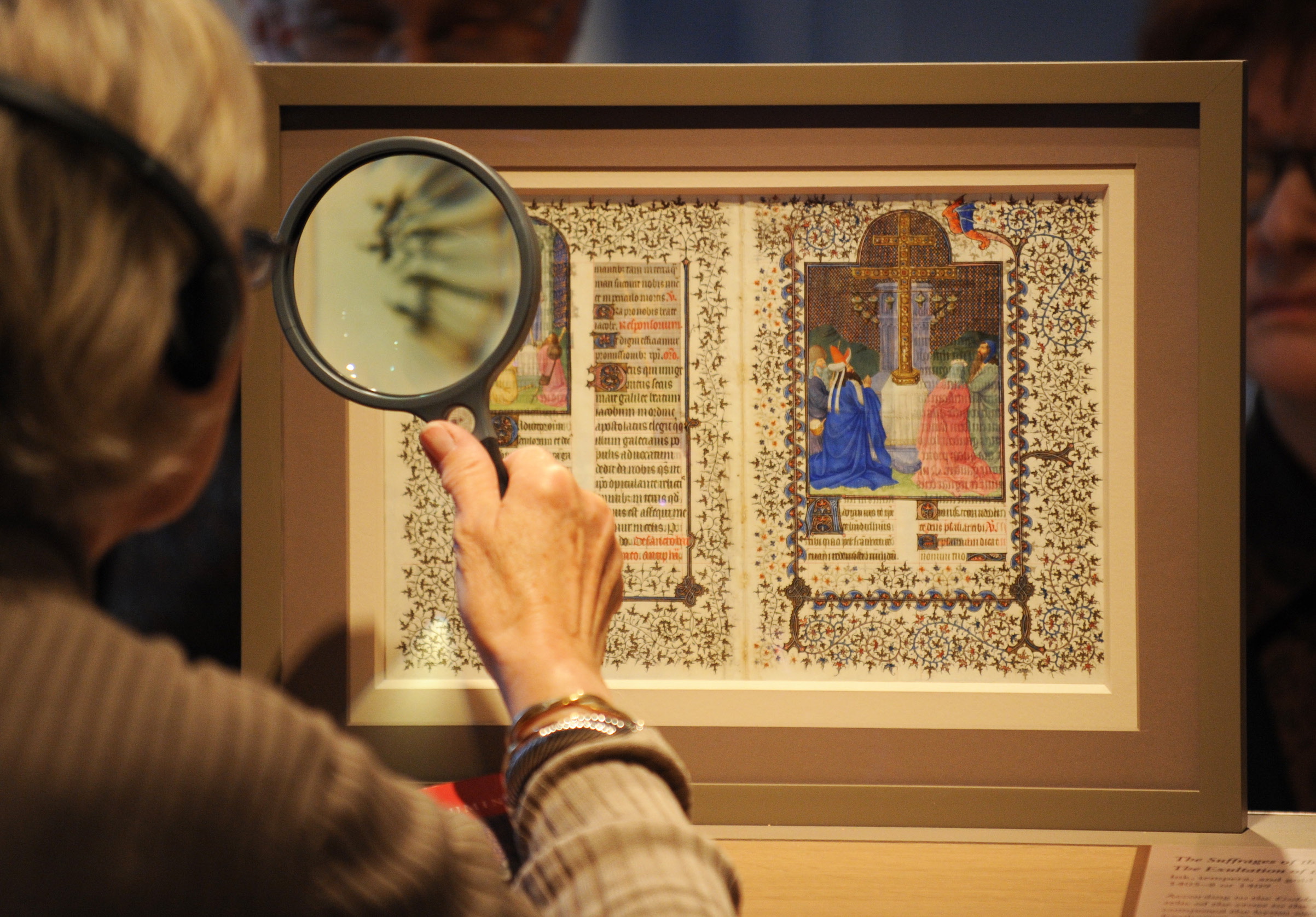 A woman uses a magnifying glass to view