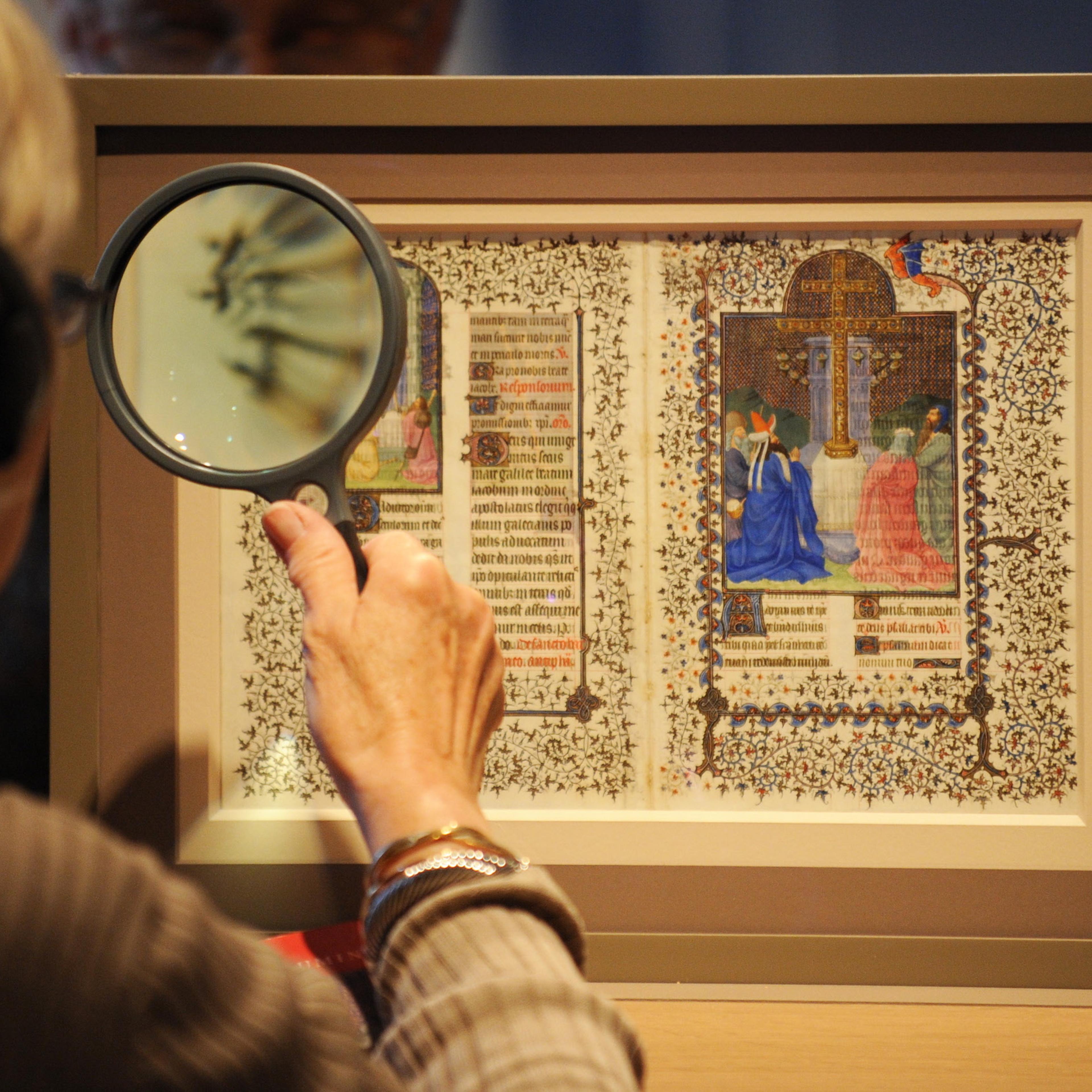 A woman uses a magnifying glass to view
