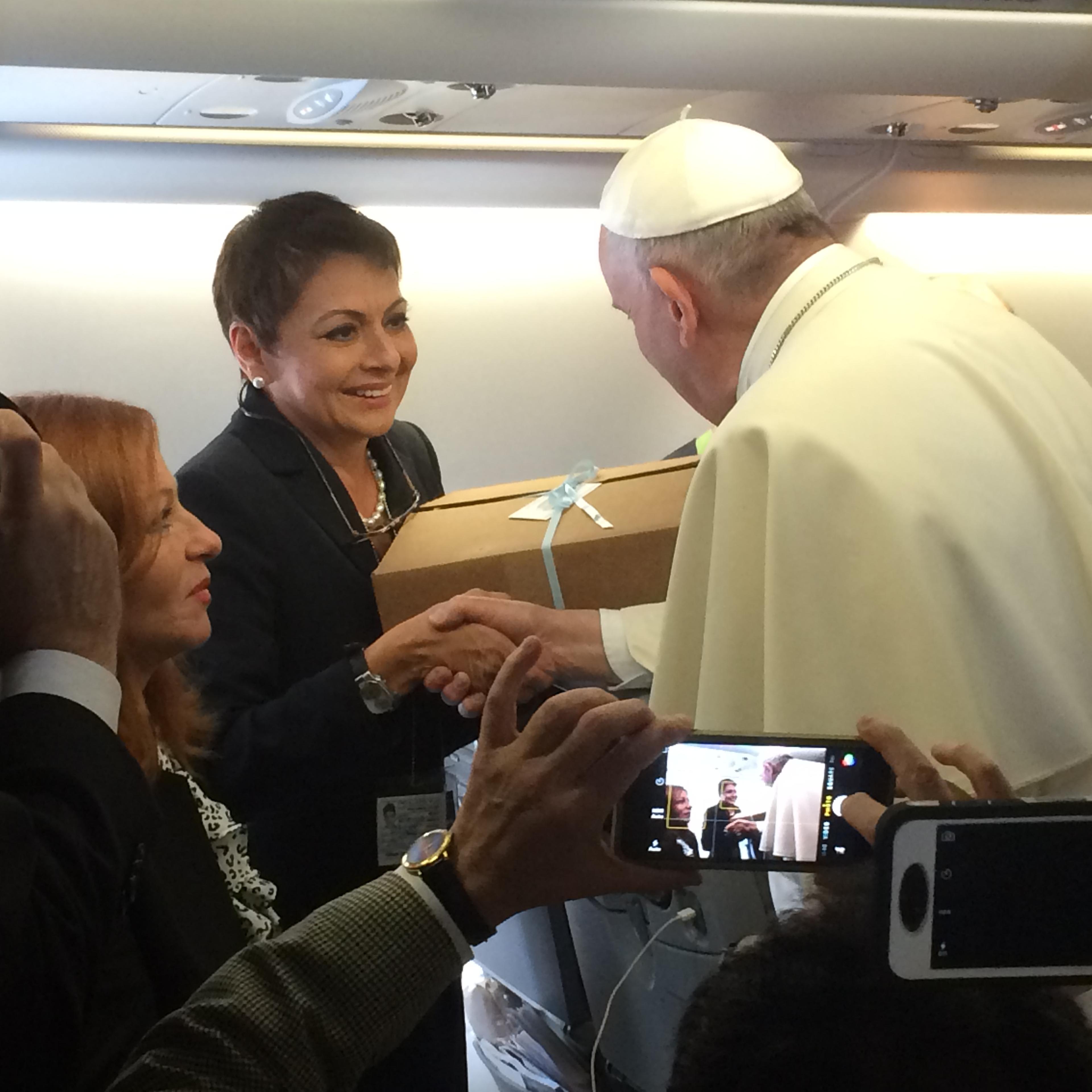Univision correspondent Maria Antonieta Collins gives Argentinian empanadas to Pope Francis aboard the papal flight from Rome to Havana.