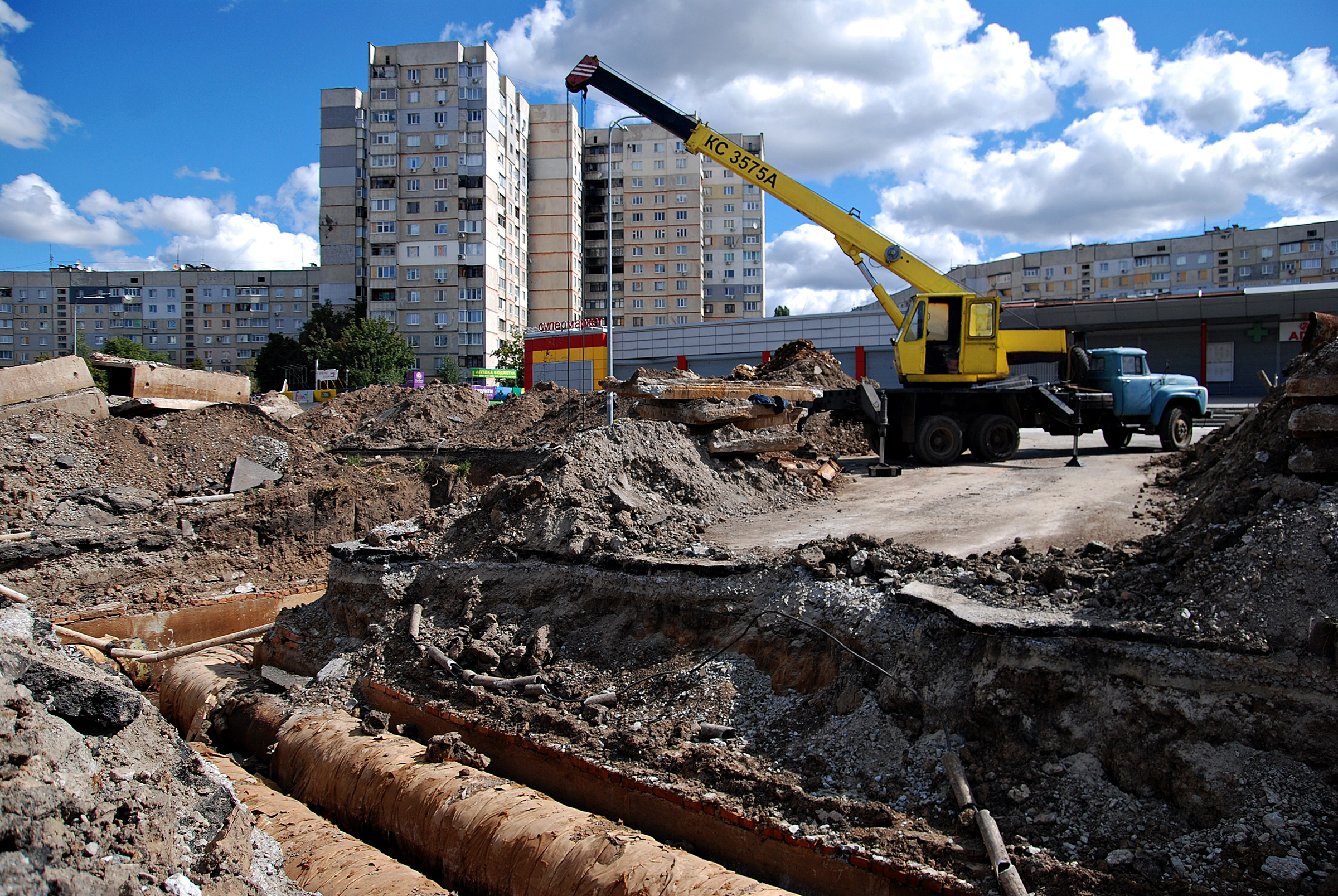 The truck crane stands next to the section of the heating main where utility workers replace old pipes on Sept. 9 in Kharkiv, Ukraine. The city authorities organized the replacement of heating pipes to reduce heat losses in the Saltivka district, despite daily shelling by Russian troops.
