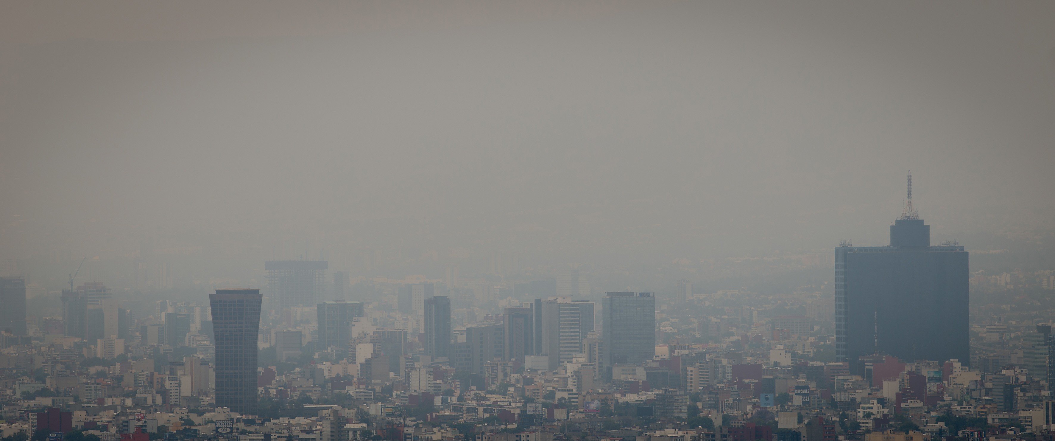 This photo shows a view of the dense smog layer covering the buildings from the look-out of the Torre Latinoamericana, in Mexico city on March 17, 2016.