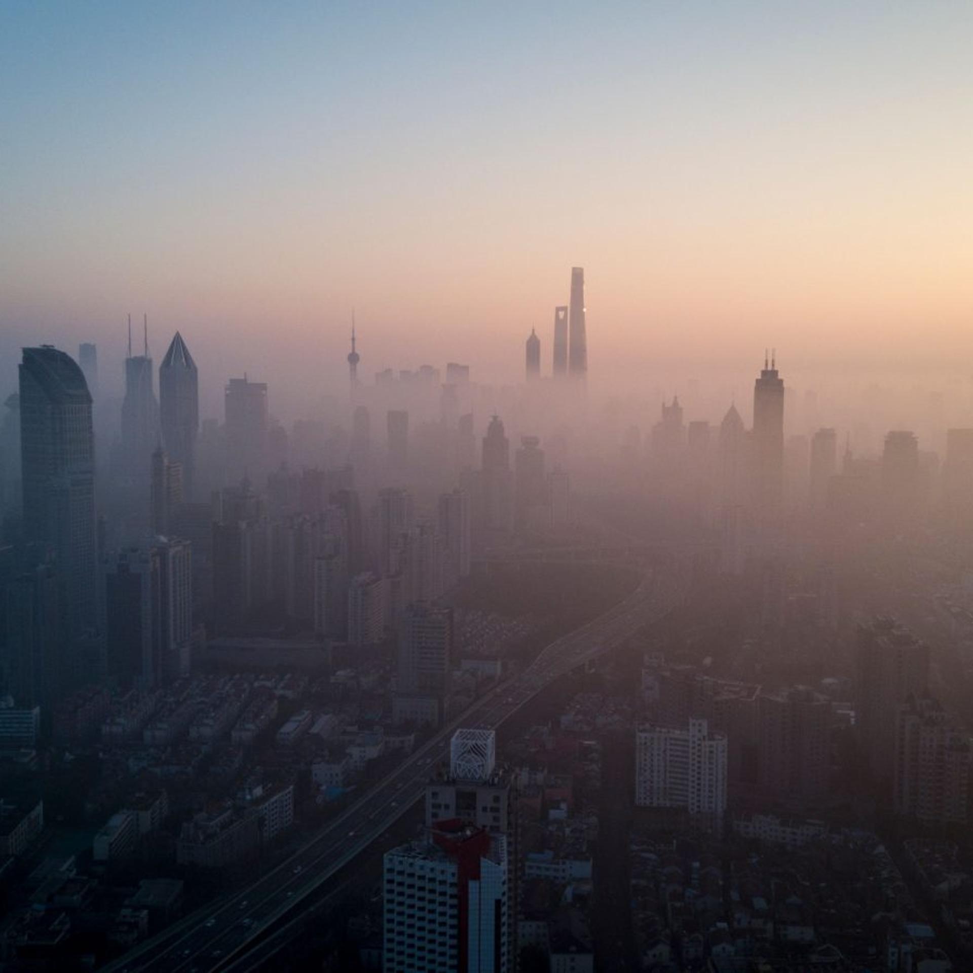 The sun rising above the skyline of a highly polluted Shanghai.