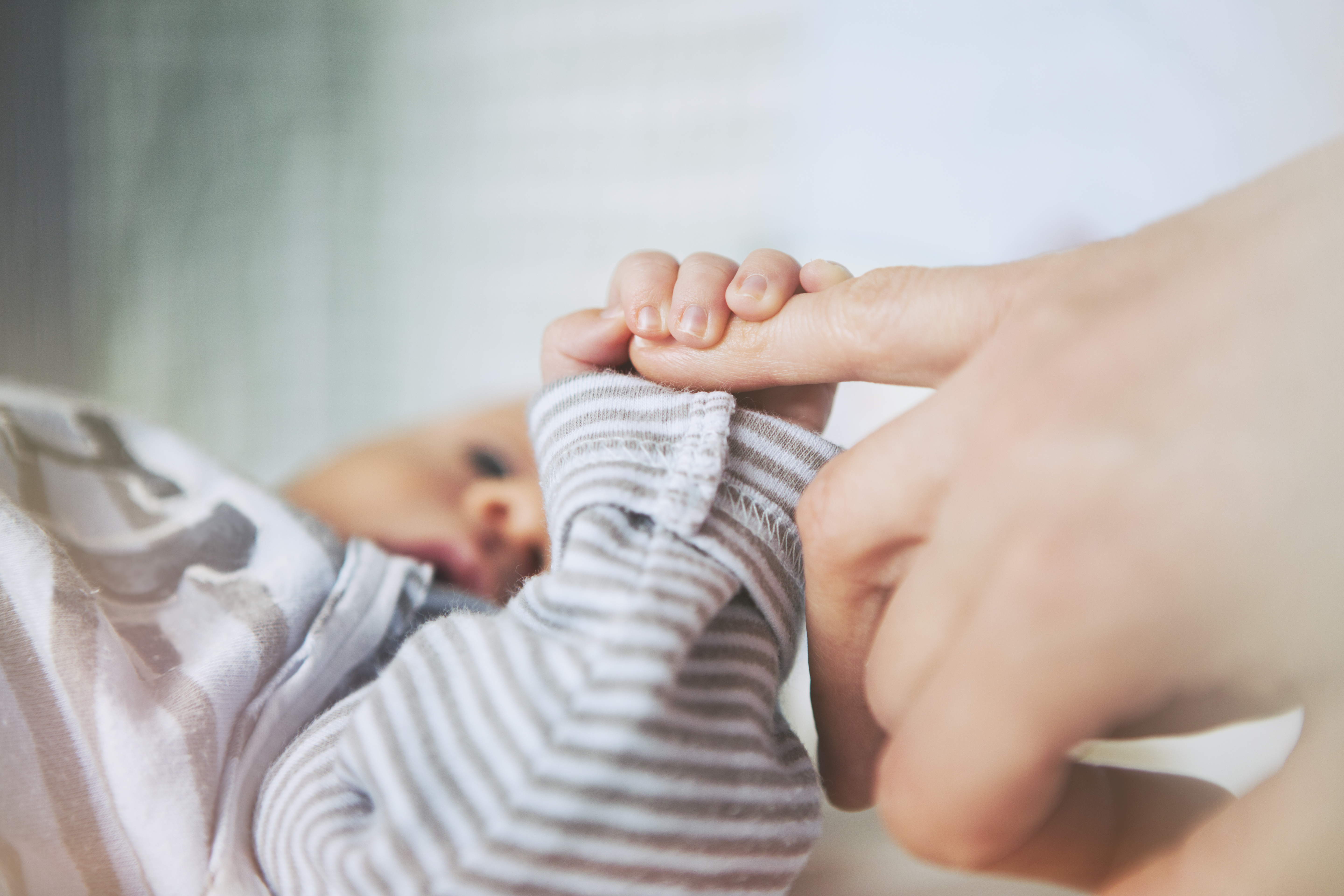 Mother holding her baby hand