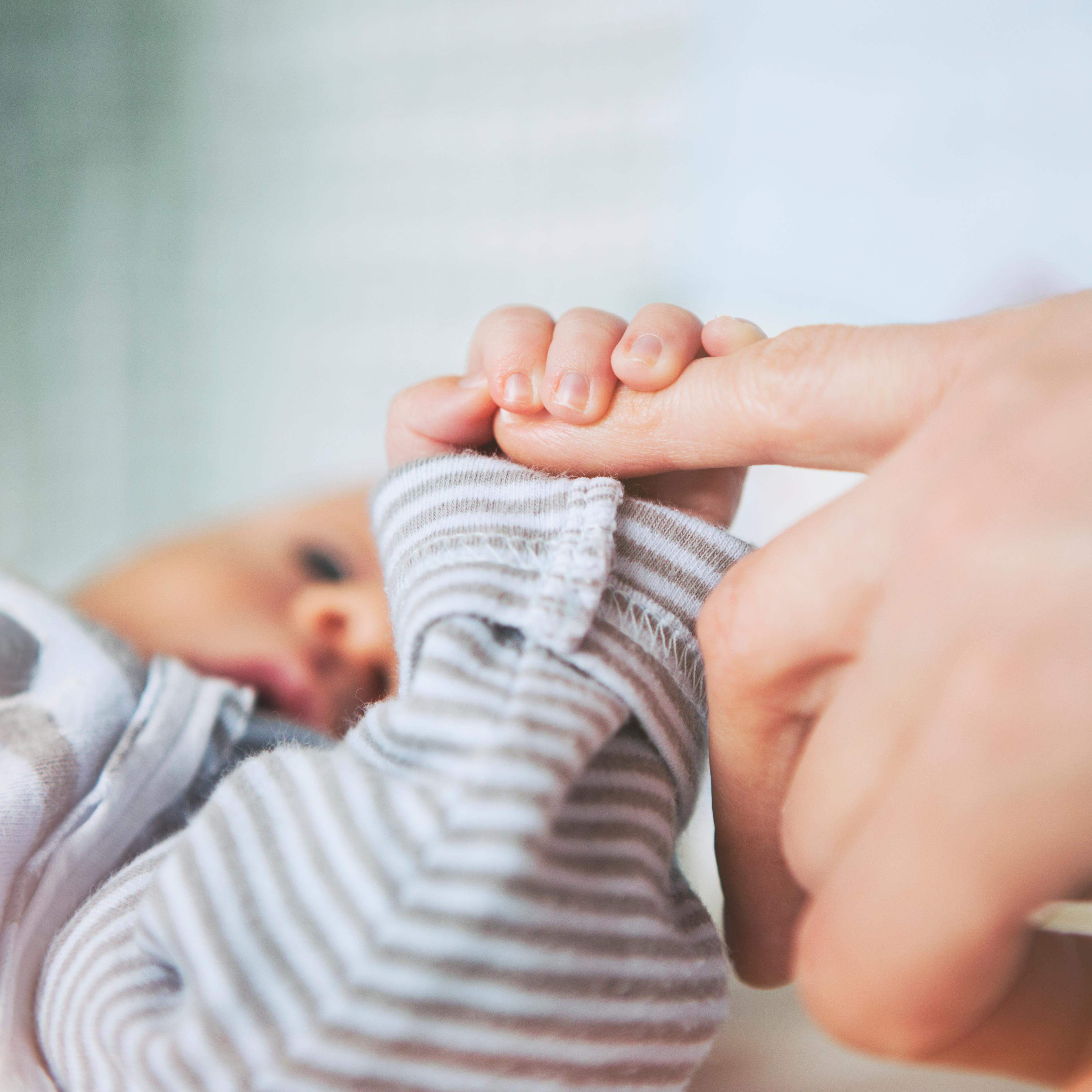 Mother holding her baby hand
