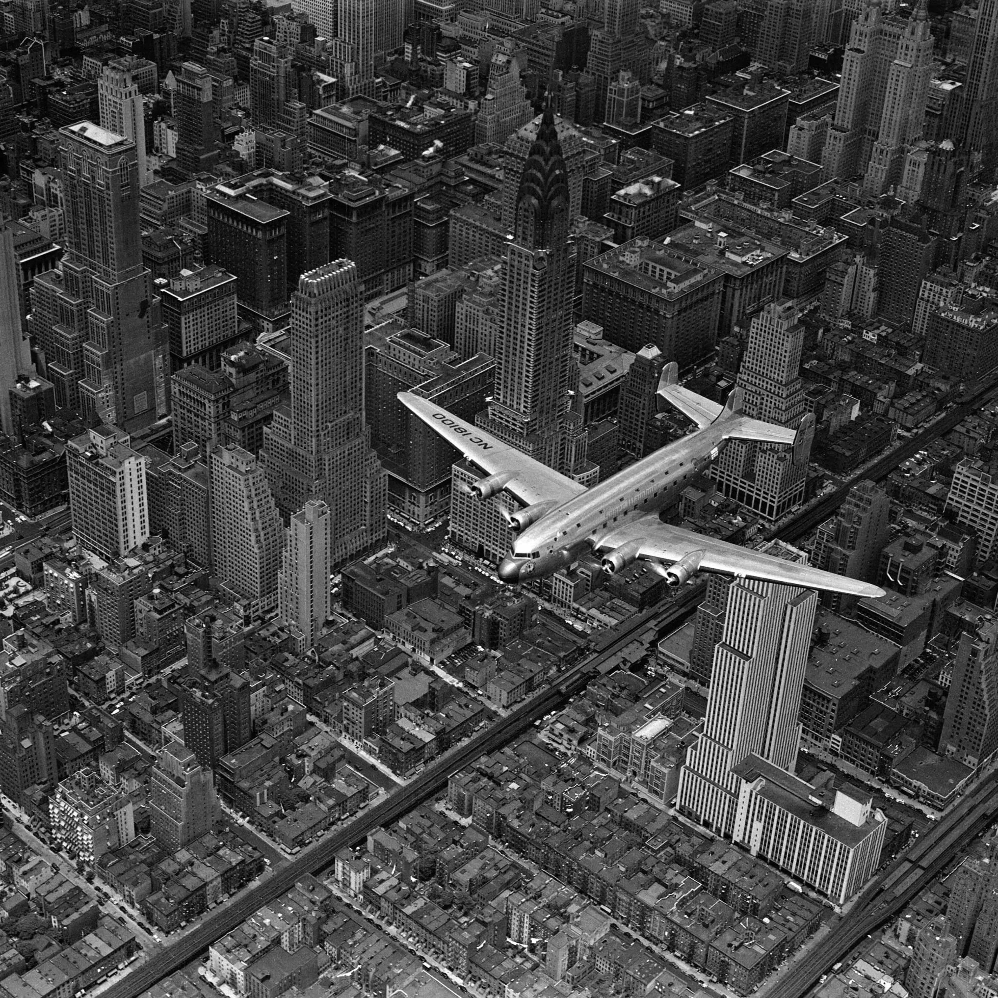 Aerial view of a DC-4 passenger plane flying over midtown Manhattan. An almost identical photograph from this shoot was published in the June 19, 1939, issue of LIFE.