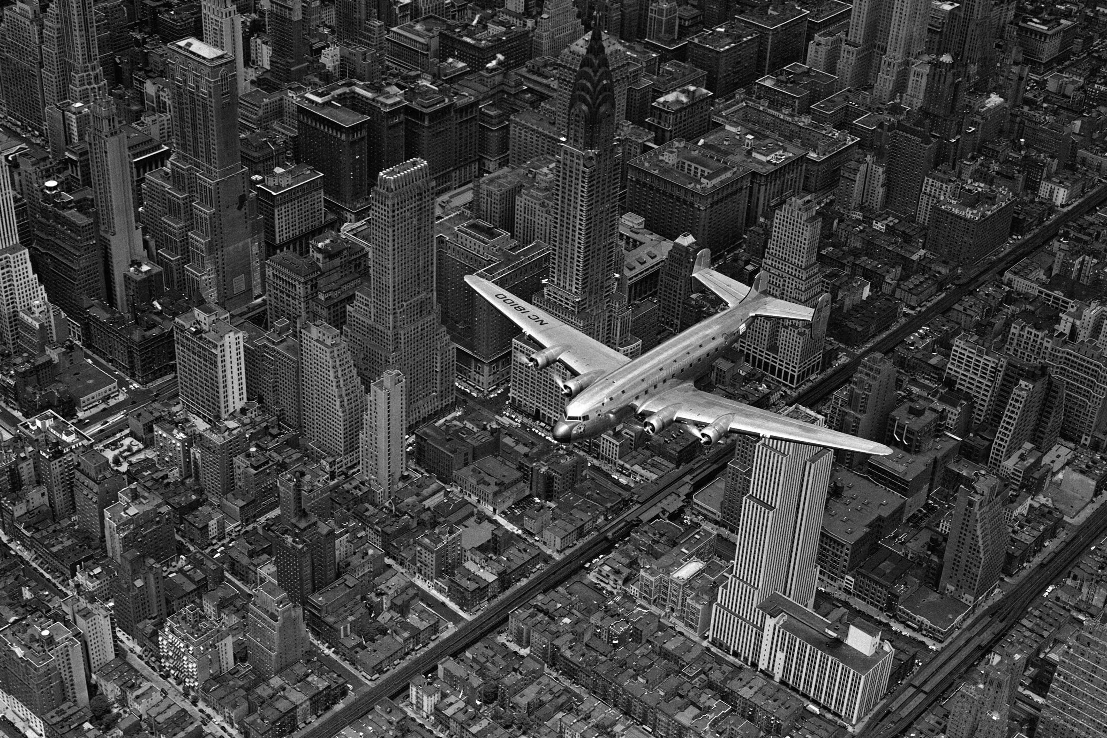 Aerial view of a DC-4 passenger plane flying over midtown Manhattan. An almost identical photograph from this shoot was published in the June 19, 1939, issue of LIFE.