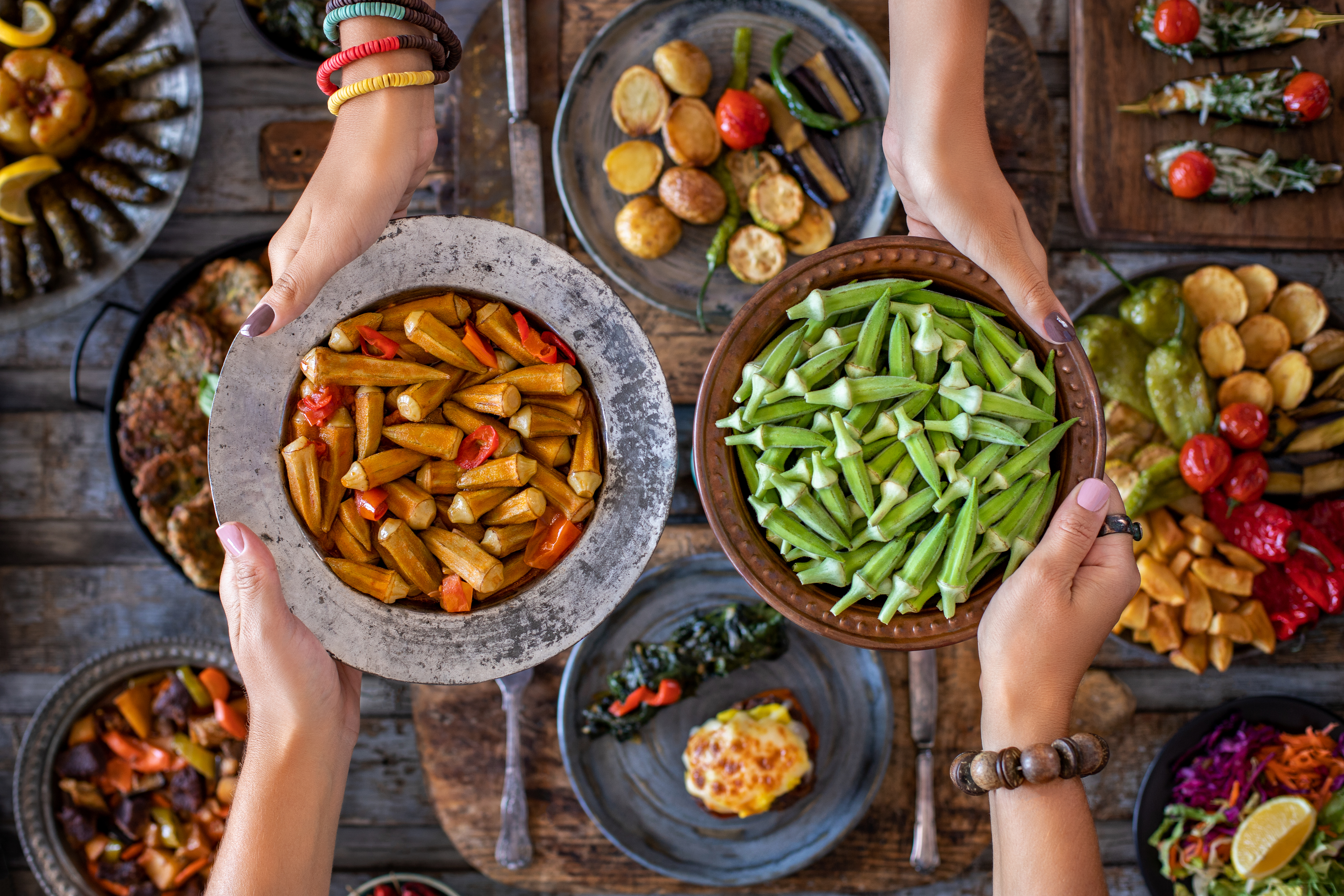 Okra in the copper bowl at the hands of two women. Sıra gecesi .