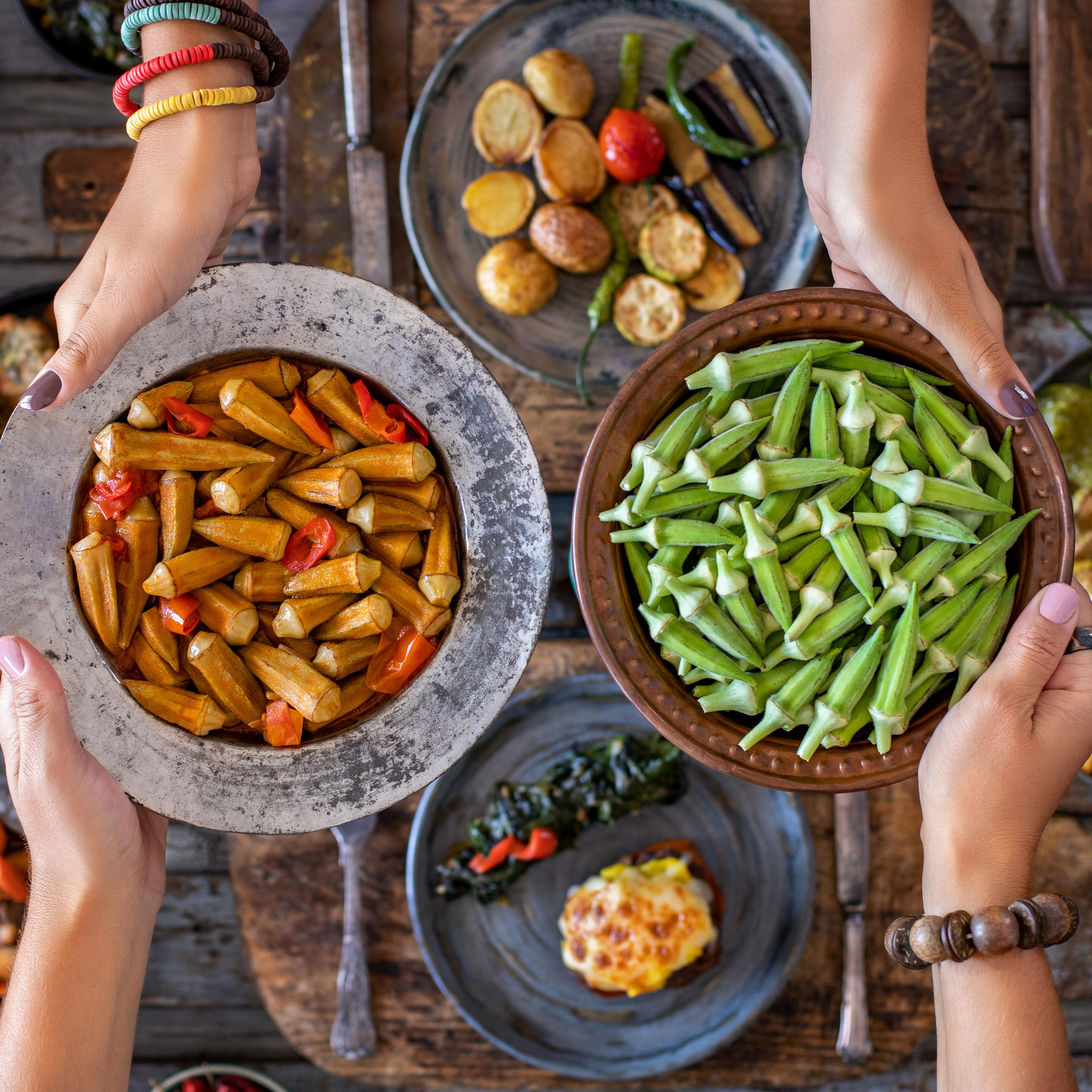 Okra in the copper bowl at the hands of two women. Sıra gecesi .