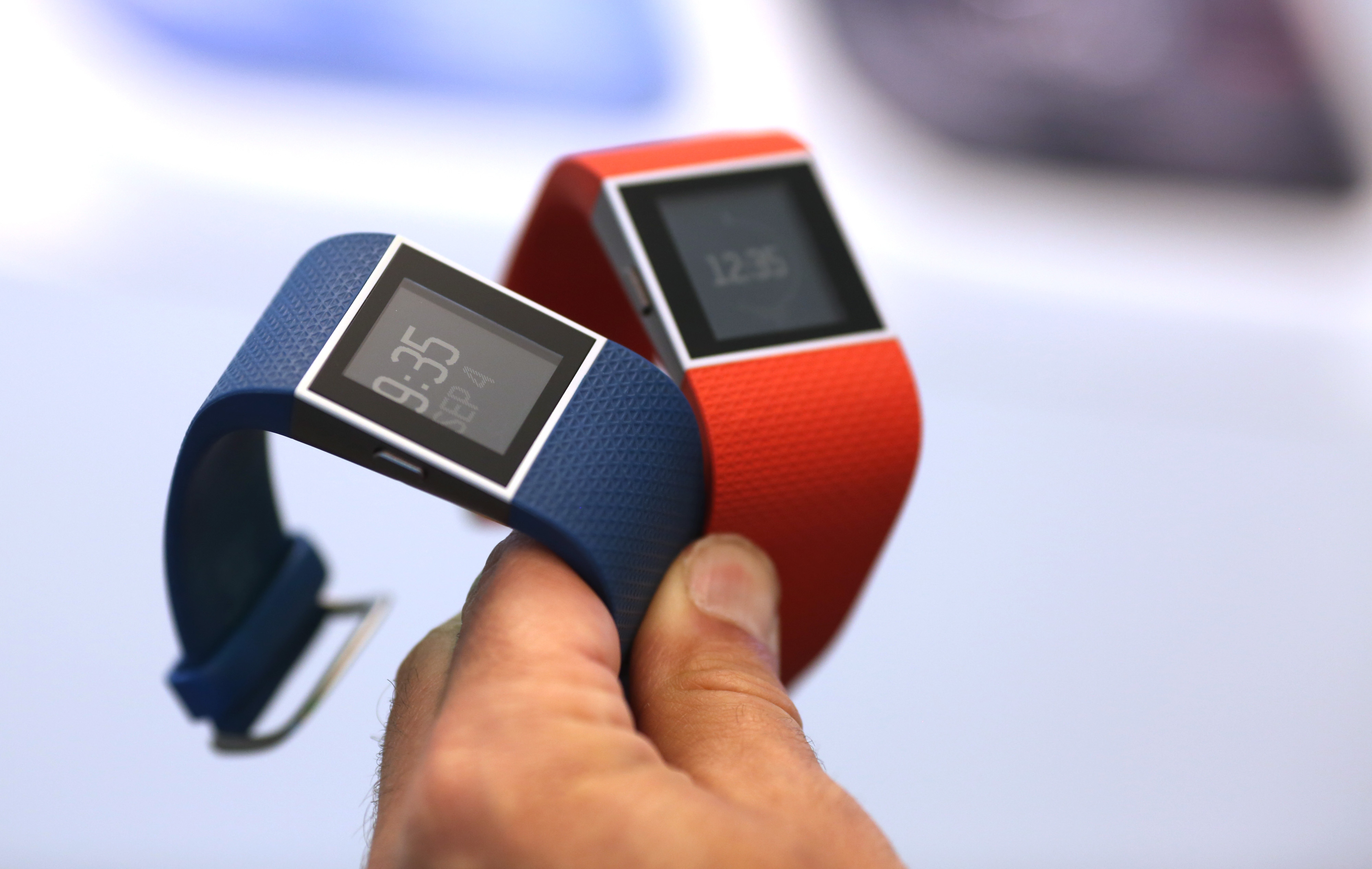 An employee holds Fitbit Inc. Surge smartwatches during the IFA International Consumer Electronics Show in Berlin, Germany, on Friday, Sept. 4, 2015.