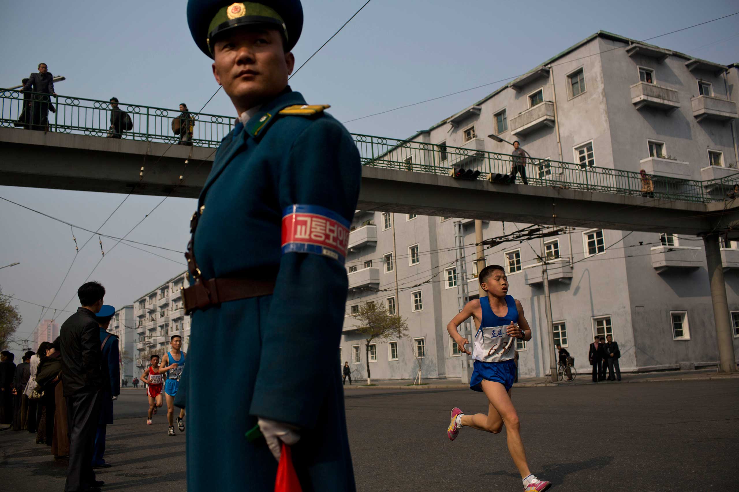 Runners pass under a pedestrian bridge in central Pyongyang during the running of the Mangyongdae Prize International Marathon in Pyongyang, North Korea in April 2014.