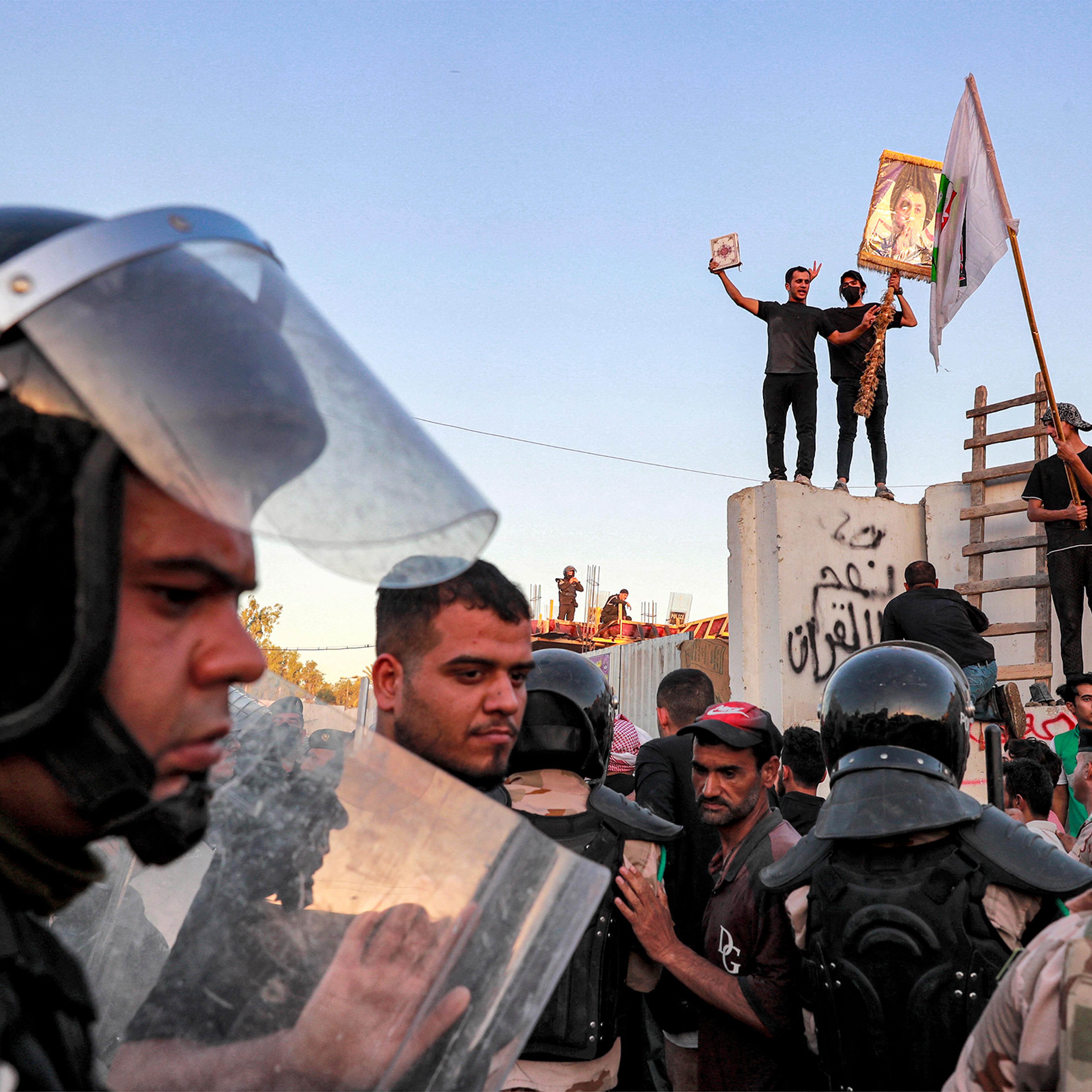 Iraqi riot police try to disperse supporters of Iraqi Shiite cleric Moqtada al-Sadr gathering for a protest outside the Swedish embassy in Baghdad on July 20. Protesters set fire to Sweden's embassy in the Iraqi capital early on July 20 ahead of a planned burning of a Koran in Sweden.