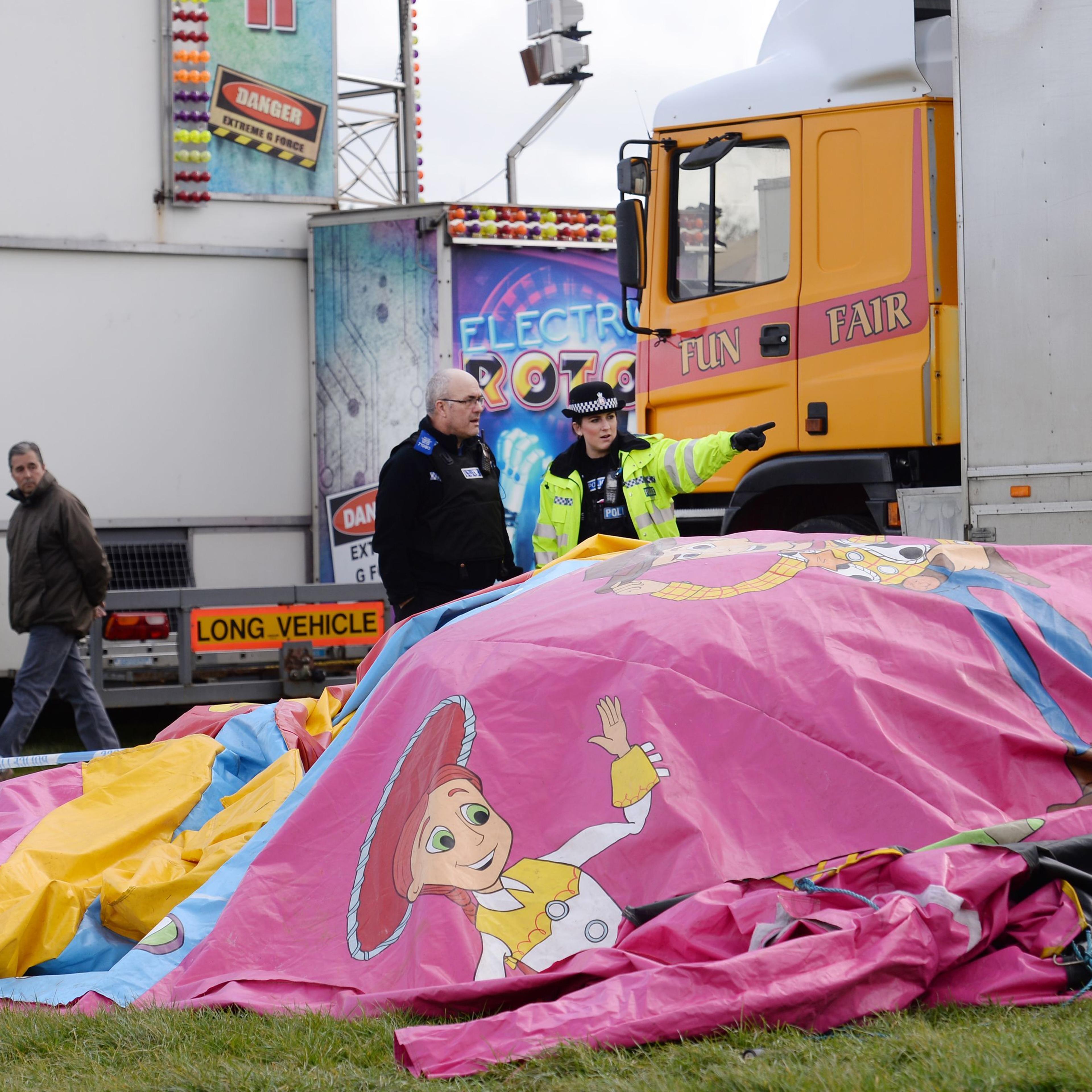Police and forensic officers attend the scene where a seven-year old girl died after she was blown by the wind about 150 metres on a bouncy castle on March 27, 2016.