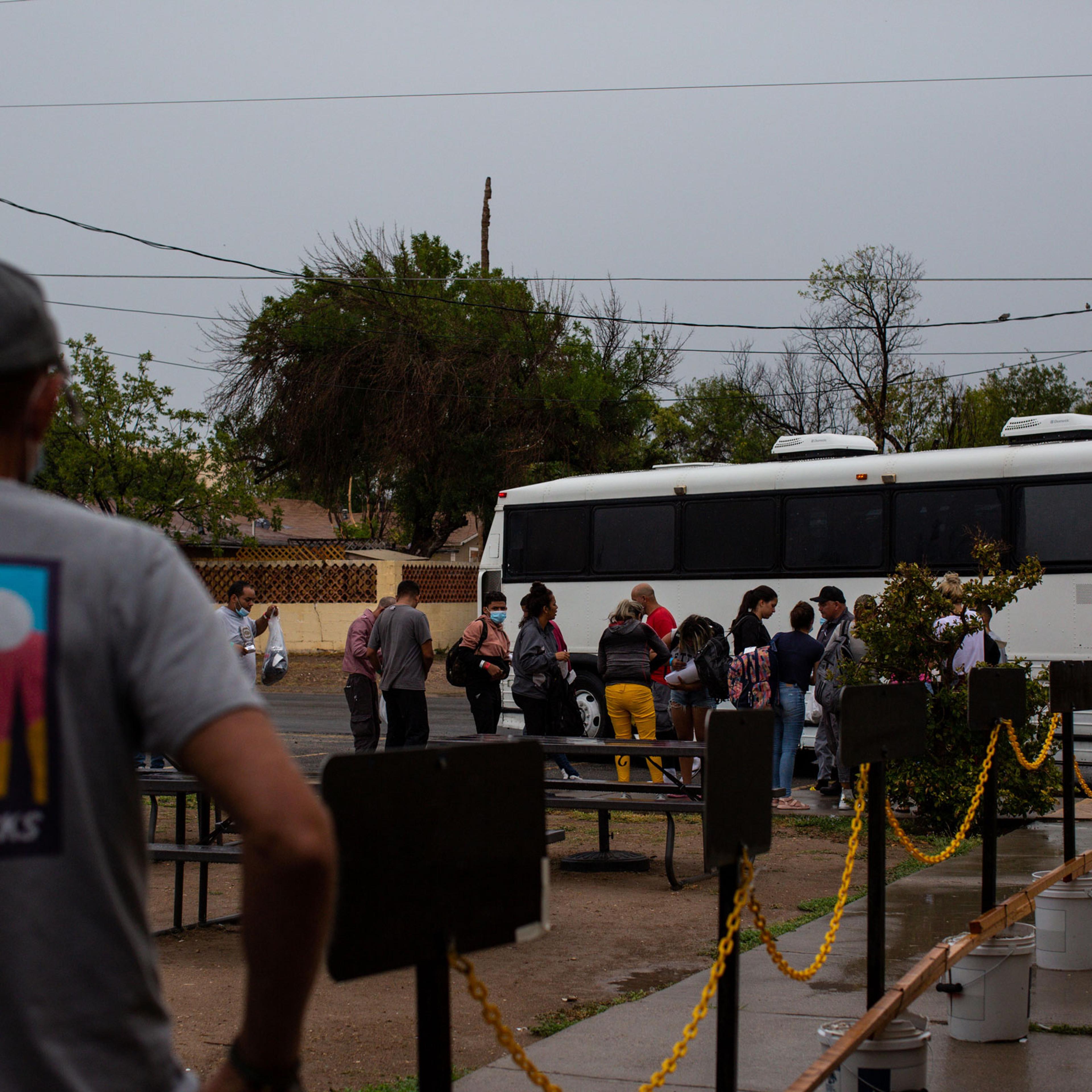 A Val Verde Border Humanitarian Coalition volunteer prepares to receive the first bus of migrants arriving for travel assistance in Del Rio
