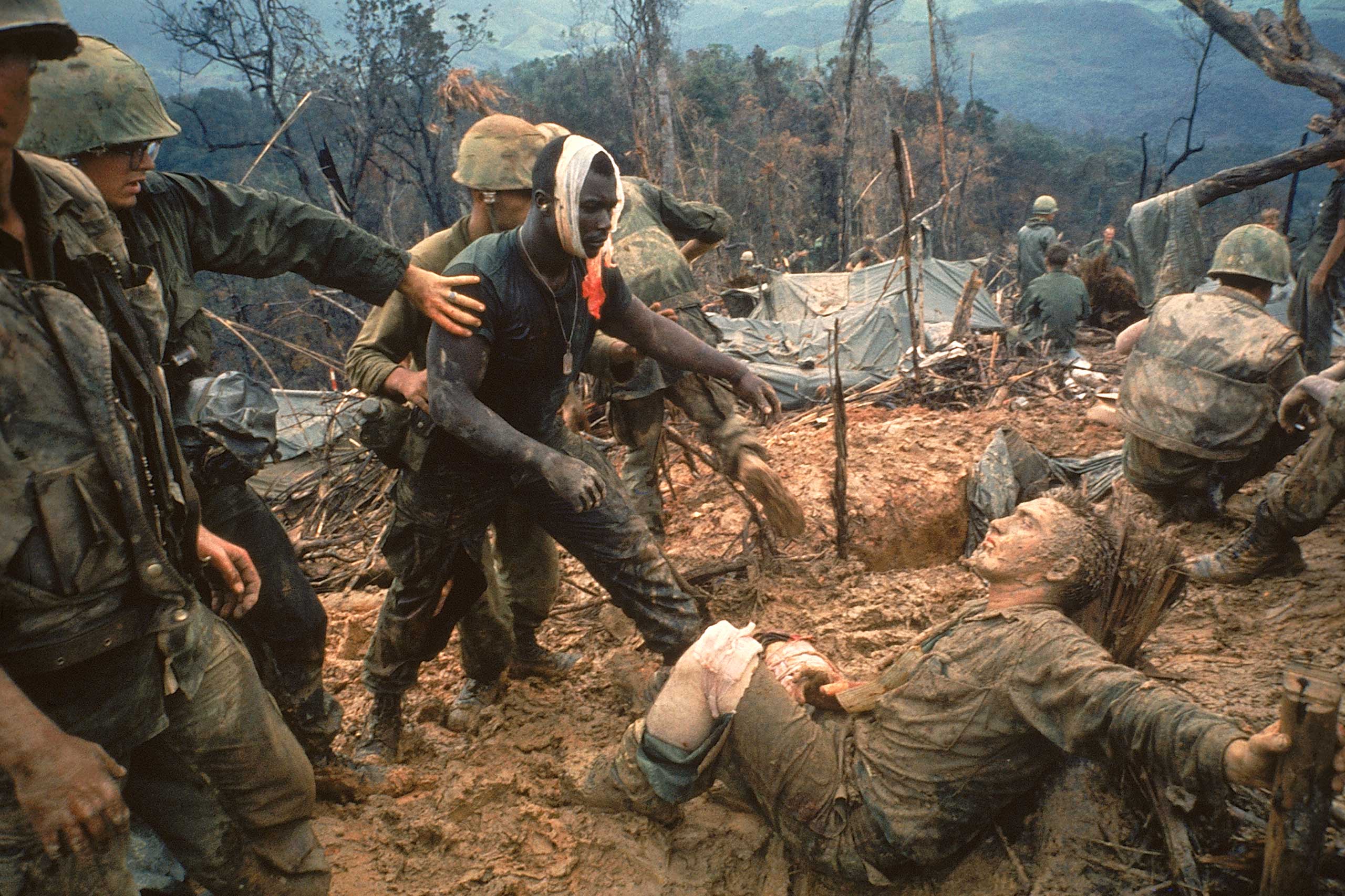 Wounded Marine Gunnery Sgt. Jeremiah Purdie (center) moves to try and comfort a stricken comrade after a fierce firefight during the Vietnam War. Photographed for an essay that ran in the October 28, 1966, issue of LIFE, this Larry Burrows picture — now 
