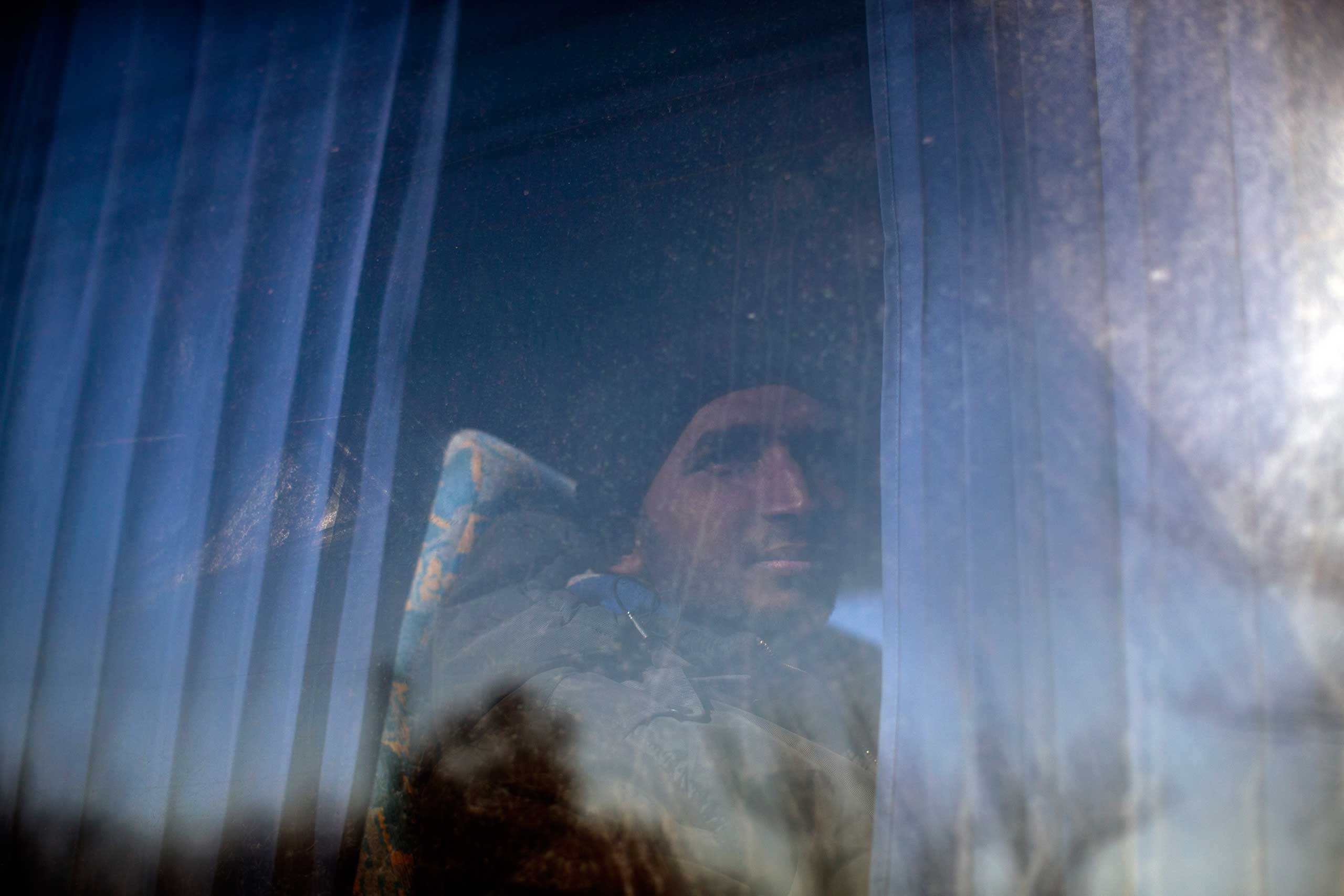 A migrant detained by the Hungarian police after illegally crossing the border with Serbia peers out of a window of a police bus in Asotthalom, some 110 miles southeast of Budapest, Hungary, on Feb. 18, 2015.