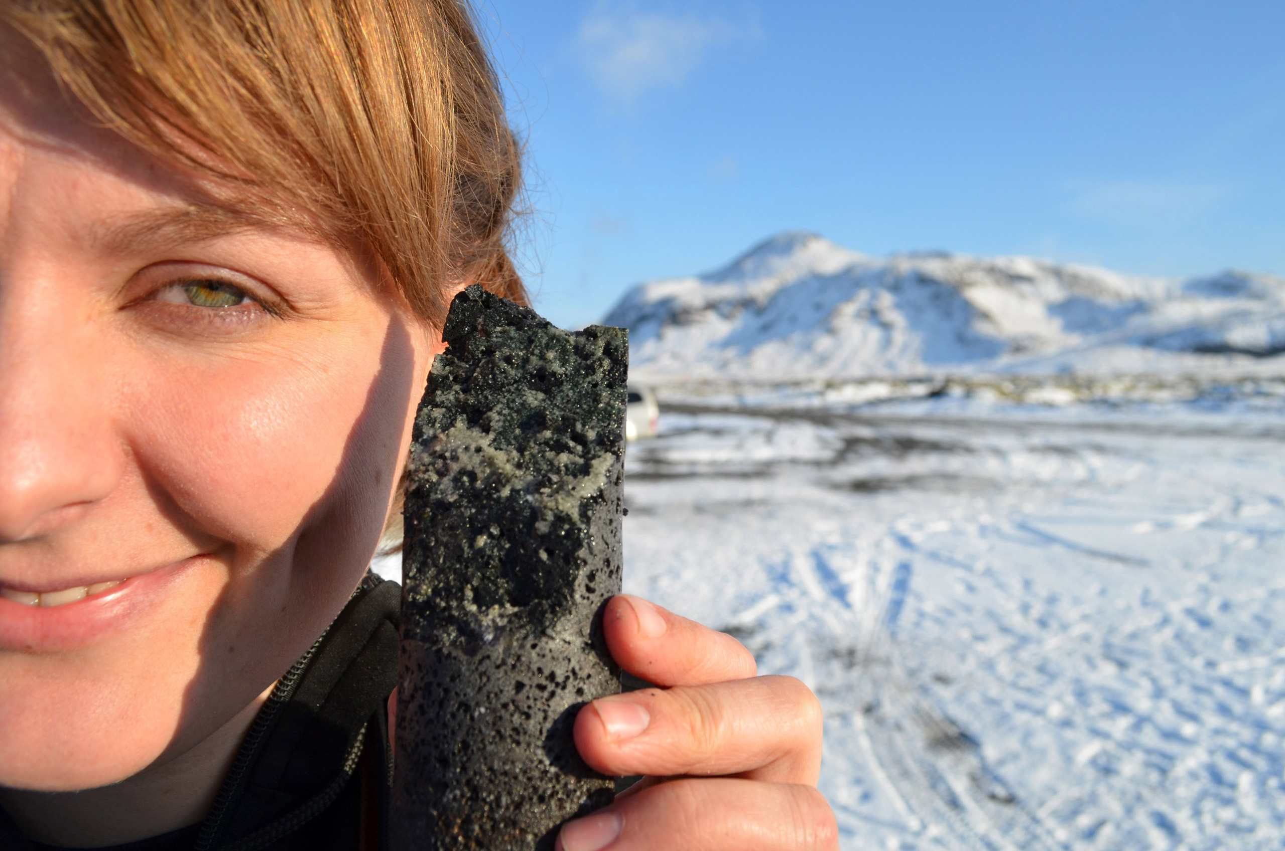 An experimental drill core held by coauthor Sandra Snaebjornsdottir in Iceland, laced with solidified carbonate, apparently produced by a new process that turns carbon emissions to stone when pumped underground.