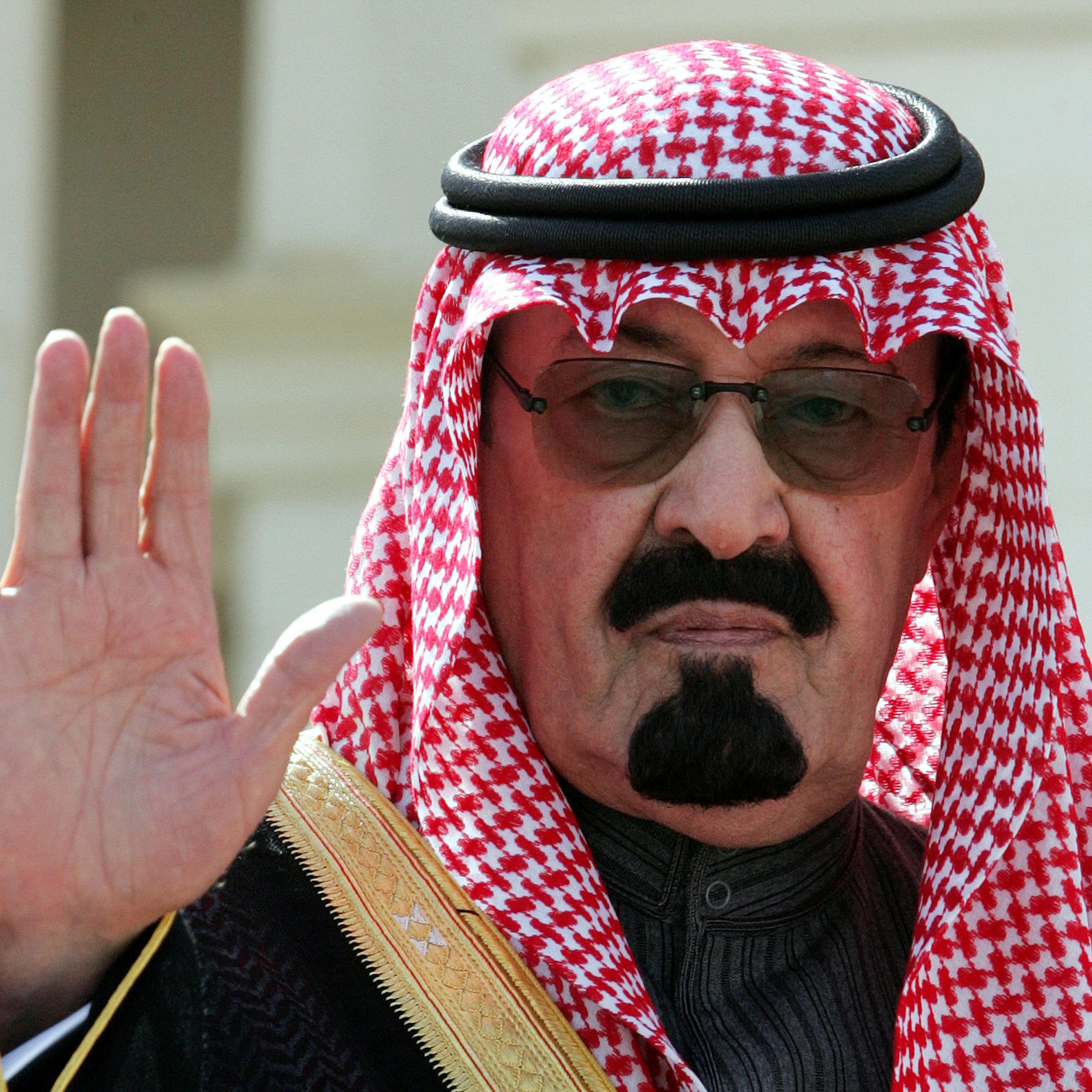 King Abdullah waves as he arrives to open a conference in Riyadh.