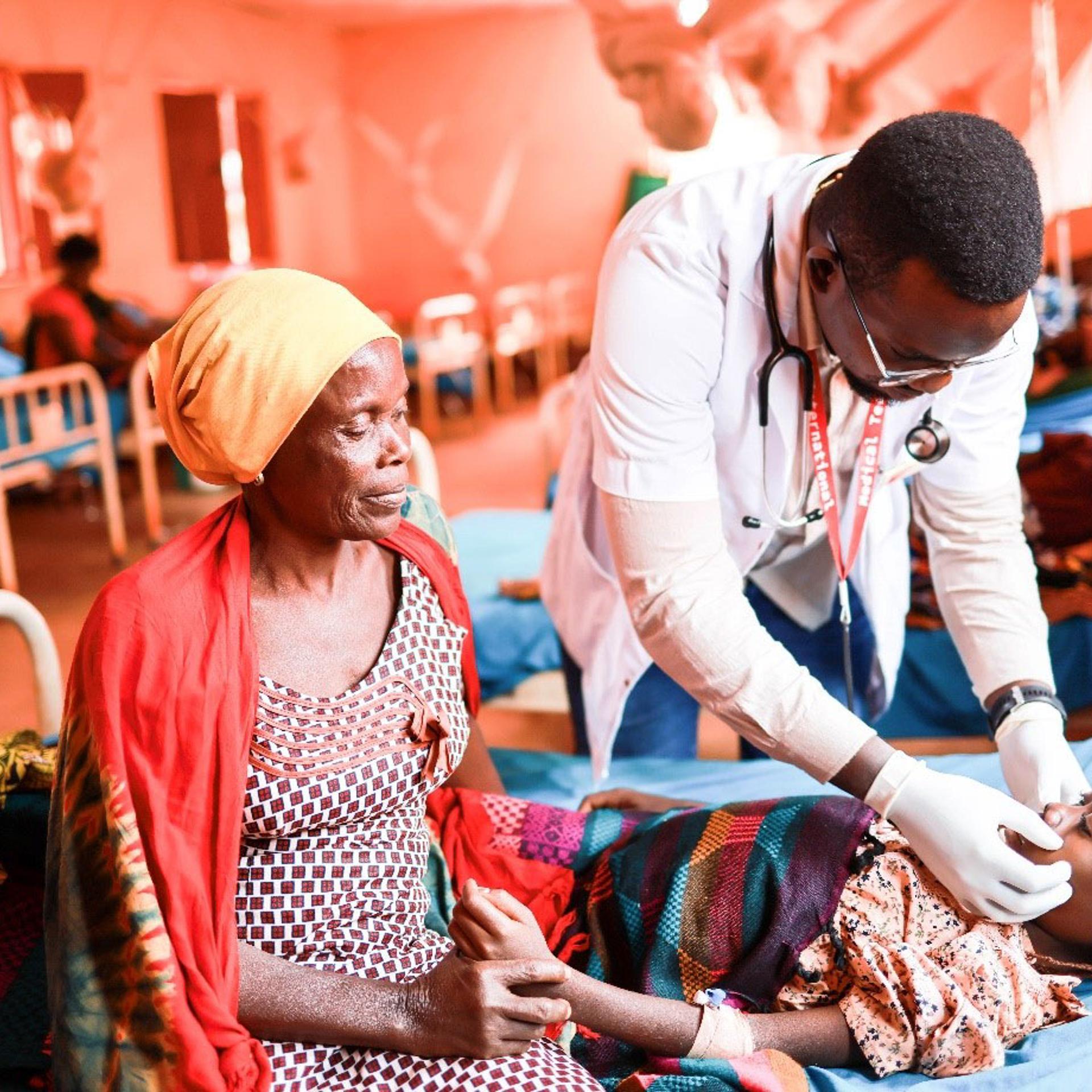 Medical Teams staff treats a hospitalized child as her mother looks on in Tanzania.
