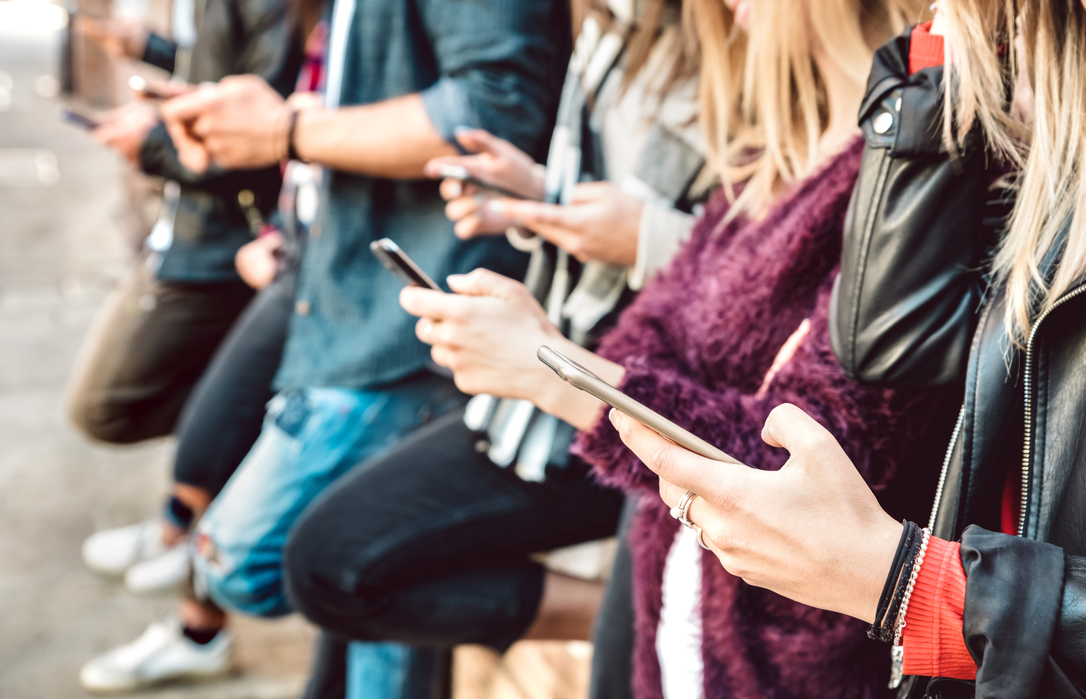 View of friends hands sharing content on mobile cell phones.