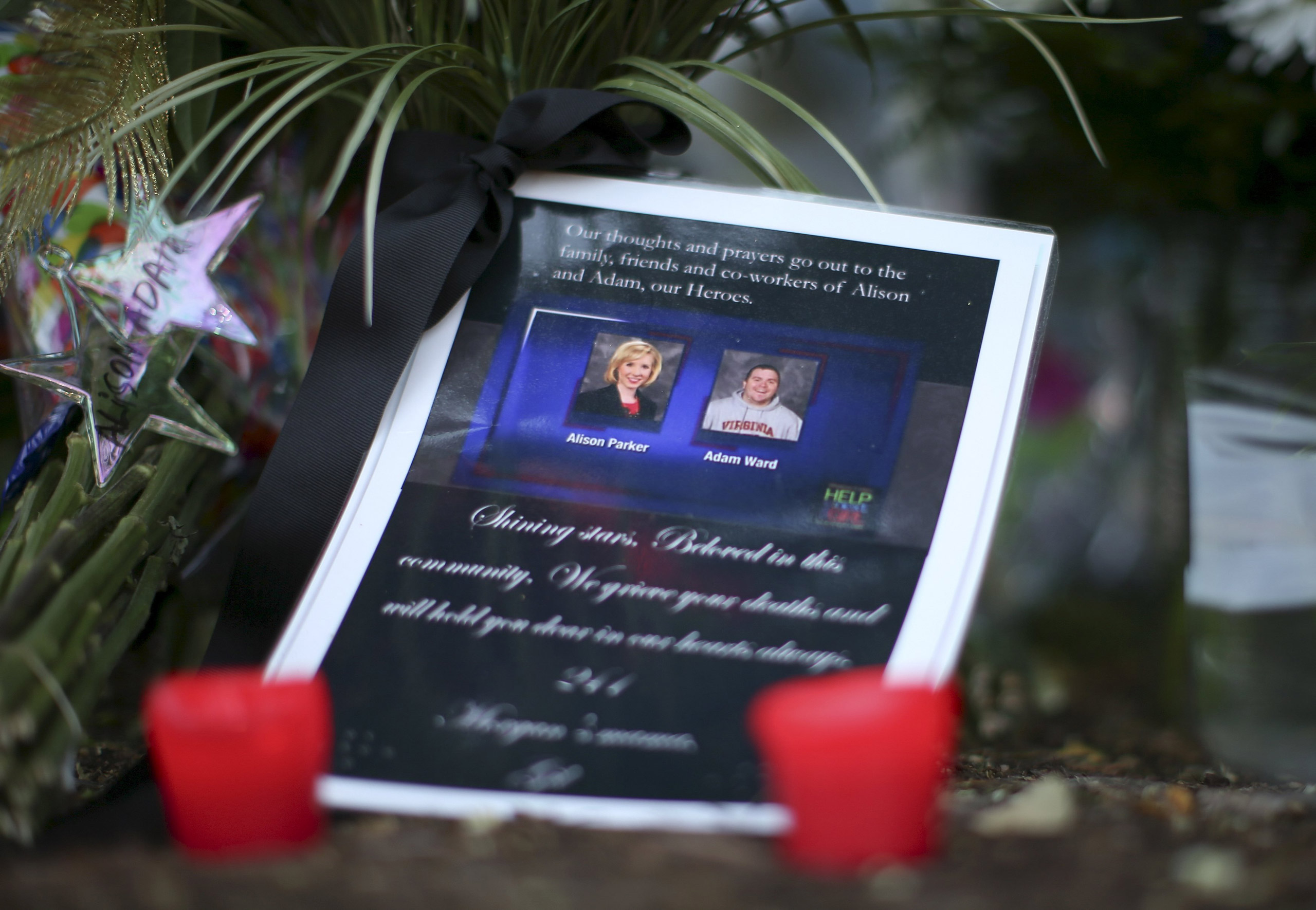 REFILE - CORRECTING TYPO IN ADAM WARD'S LAST NAMEA picture of slain journalists Alison Parker and Adam Ward is seen next to candles at a memorial outside of the offices for WDBJ7 in Roanoke, Virginia August 27, 2015. Parker, 24, and Ward, 27, were shot d