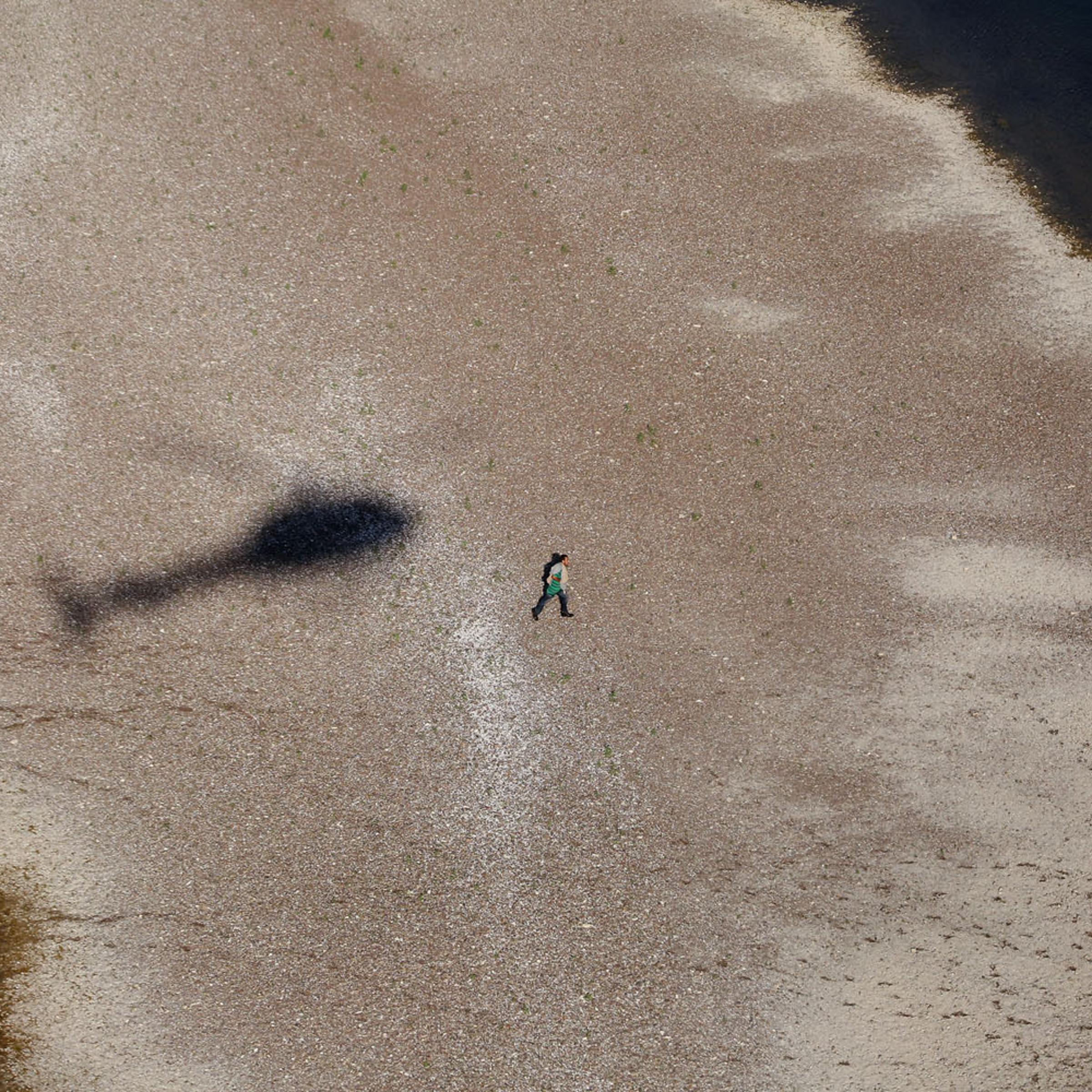 A suspected migrant runs back to Miguel Aleman, Mexico after being pursued by agents near Roma, Texas. Oct. 8, 2014.