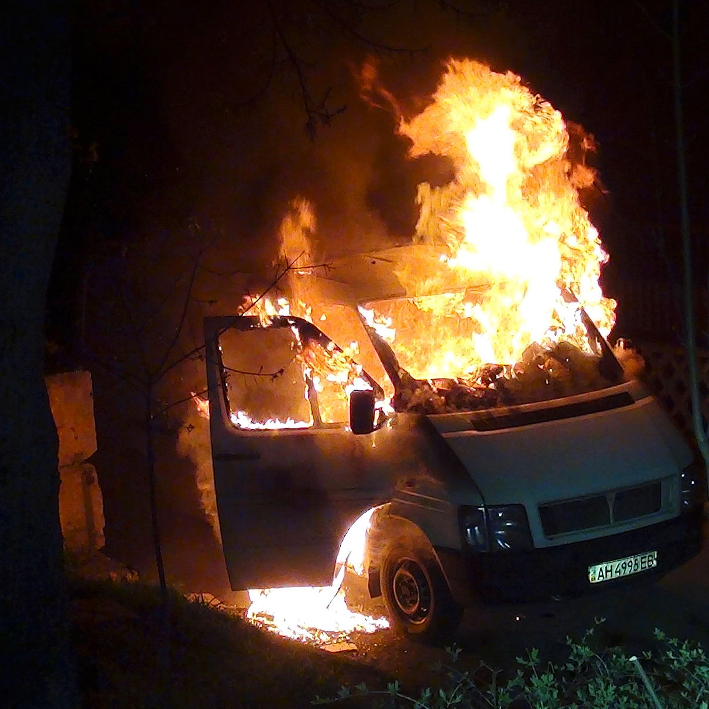 A minivan burns at the gates to a National Guard base in Mariupol, early Thursday, April 17, 2014