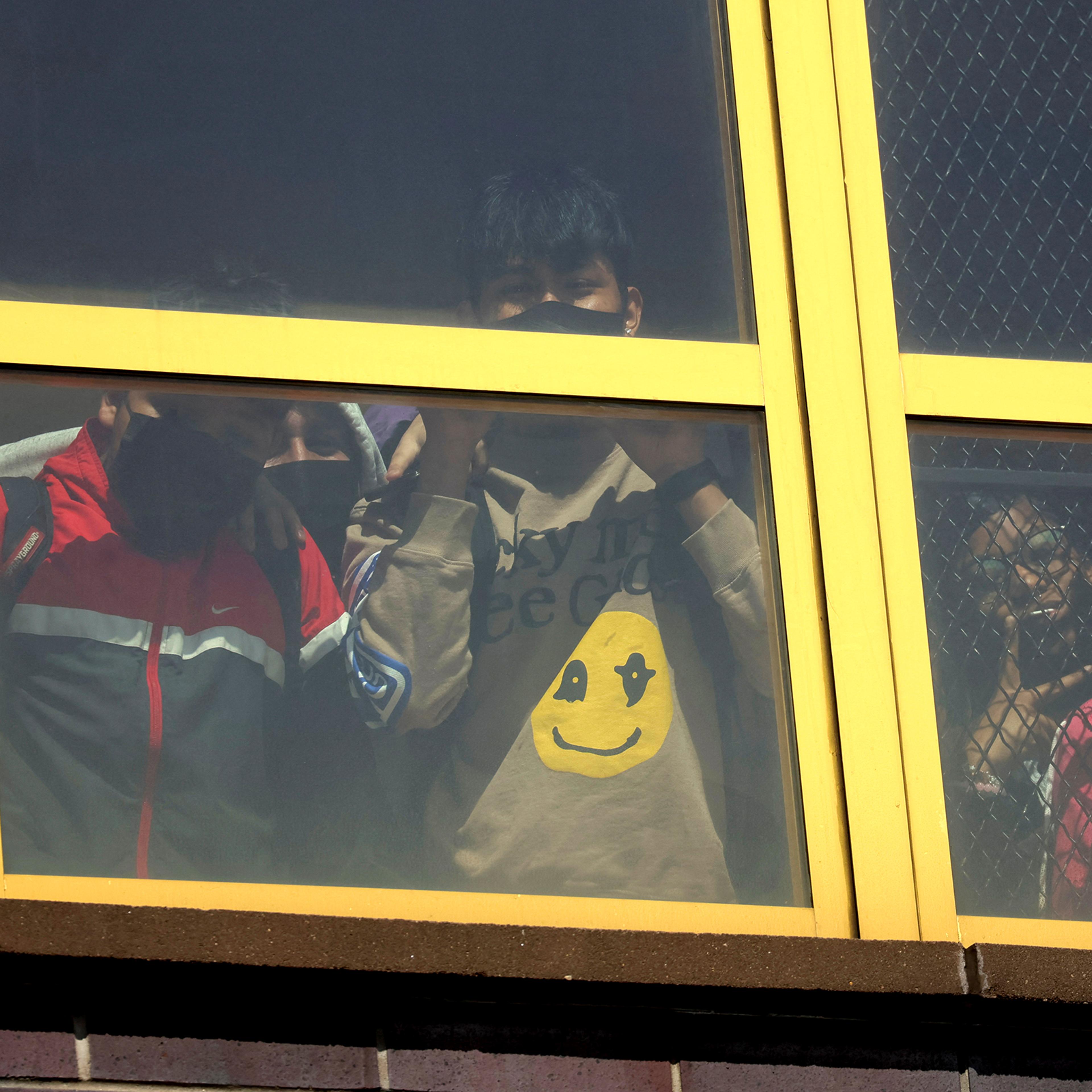 Children look out from a window near the scene of a shooting at a subway station in the Brooklyn borough of New York City