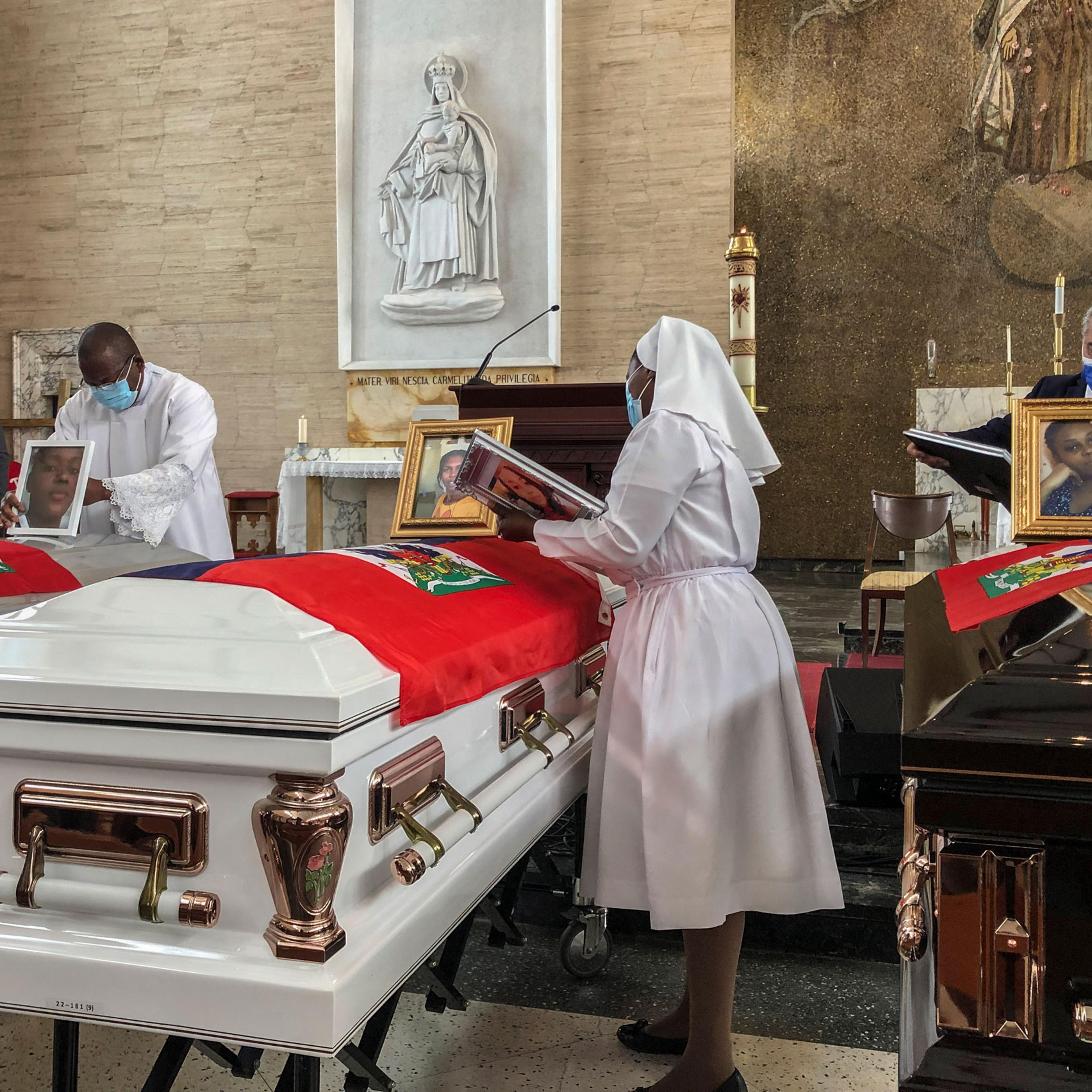 Church officials set up photos of the 11 Haitian women who died last month when the overloaded boat they were in capsized, at a church in San Juan, Puerto Rico
