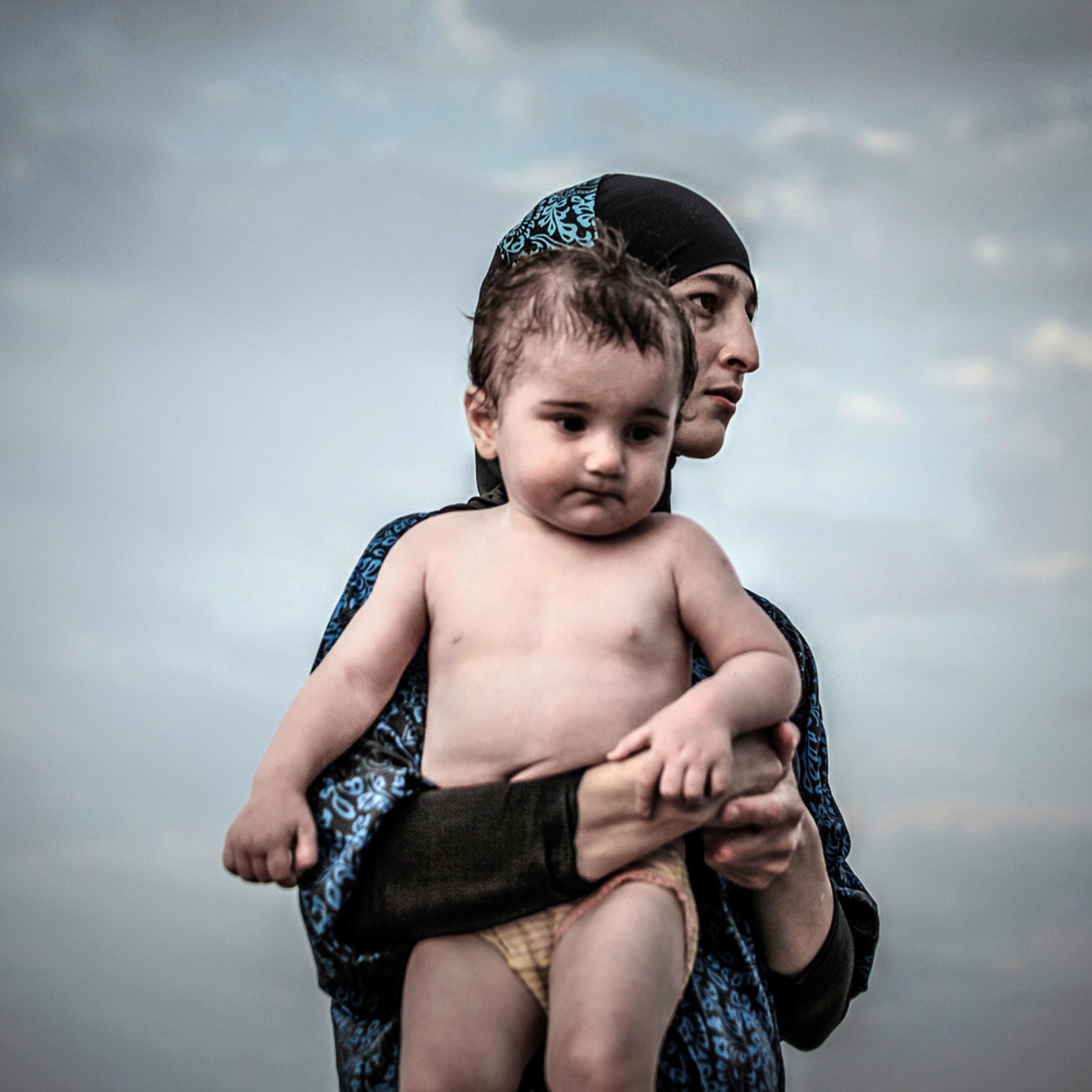 A Salafi woman with a child seen in a street of Kaspiysk.