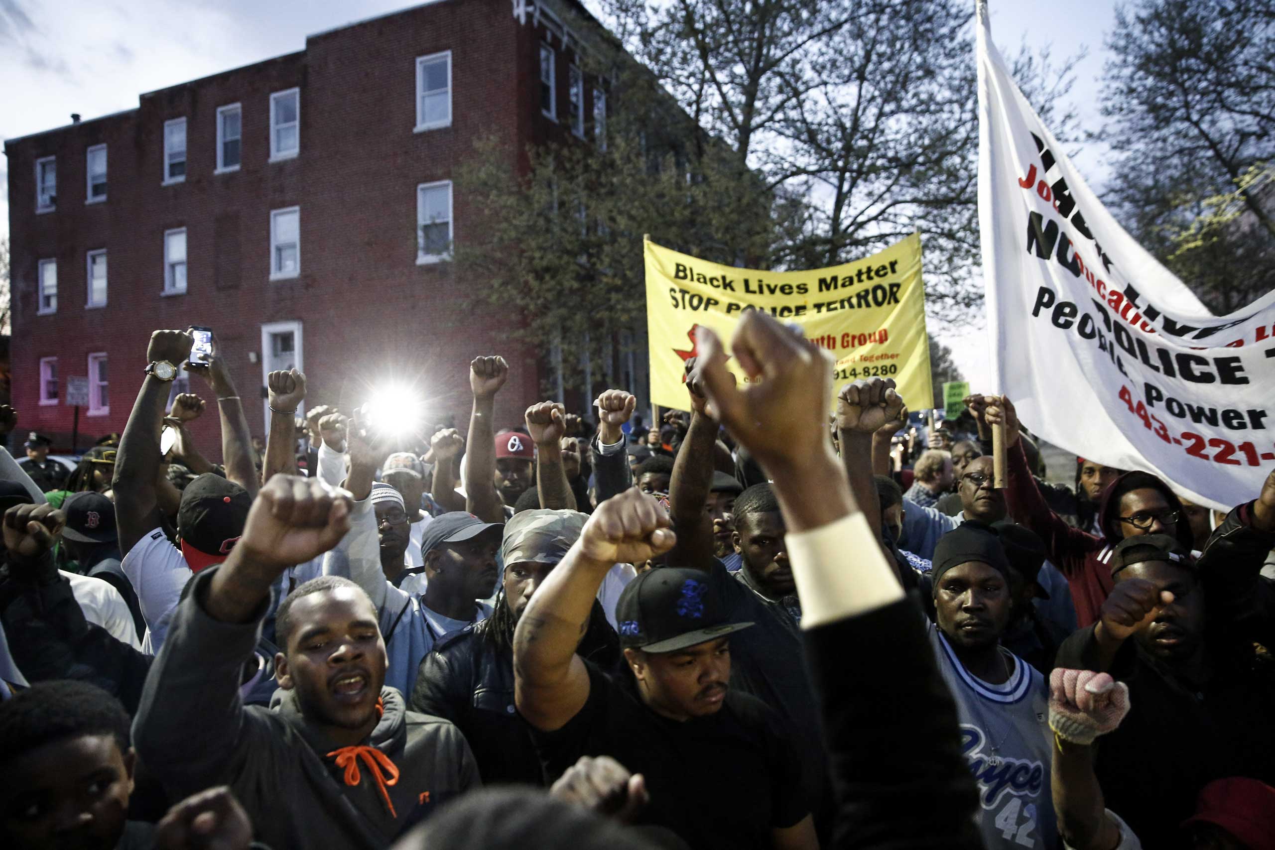 Protestors participate in a vigil for Freddie Gray down the street from the Baltimore Police Department's Western District police station in Baltimore on April 21, 2015.