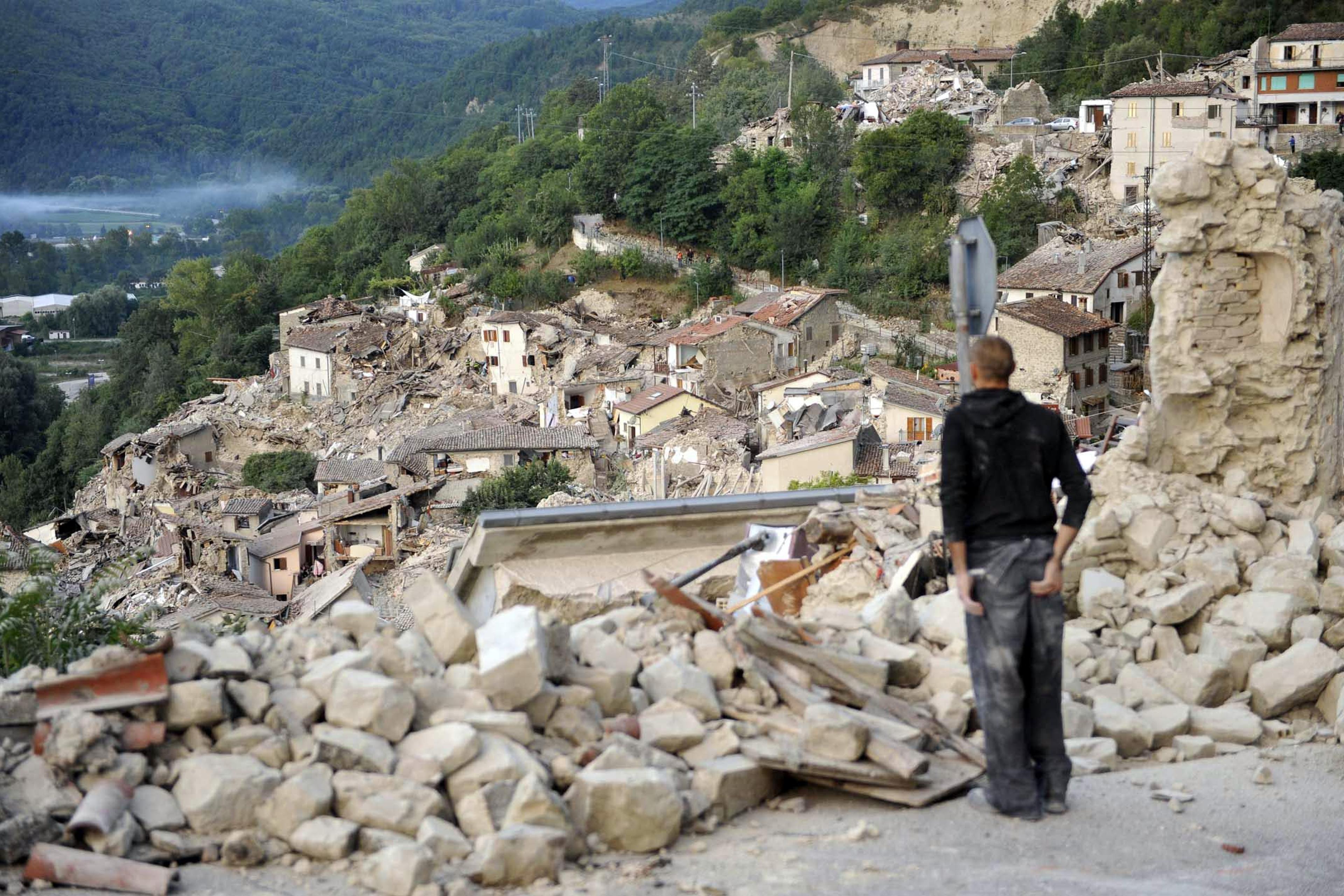 A man observes the rubble in Pescara del Tronto, near Arquata del Tronto, Ascoli Piceno, in Marche Region, Italy, on Aug. 24, 2016.