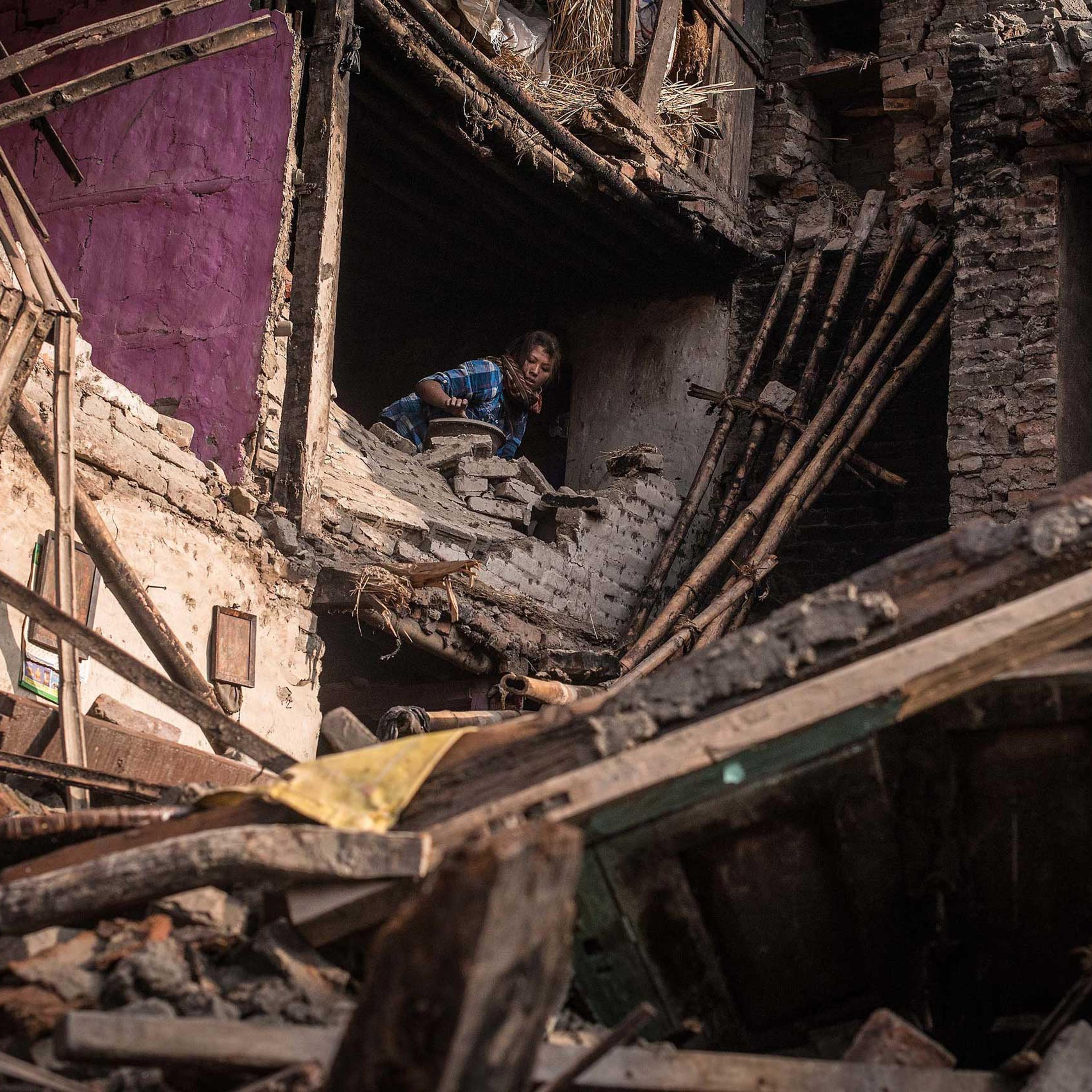 A victim of the earthquake searches for her belongings among debris of her house on in Bhaktapur, Nepal on April 29, 2015.