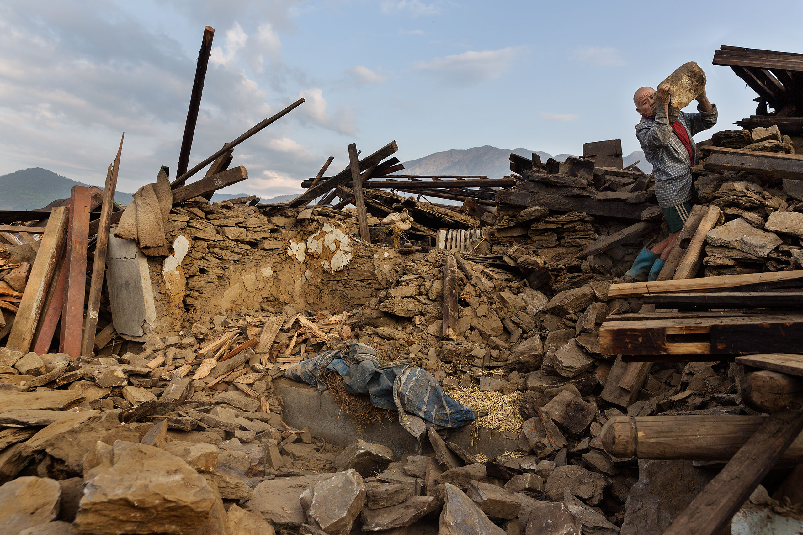 Nepal earthquake. Barpak, the epicenter of the earthquake. Funeral of Pur Bahadur Gurung, 26, who had just been dug out of the rubble. Saainli Gurung, his mother weeping. Scenes of villagers salvaging building materials and personal possessions. Dhan Raj