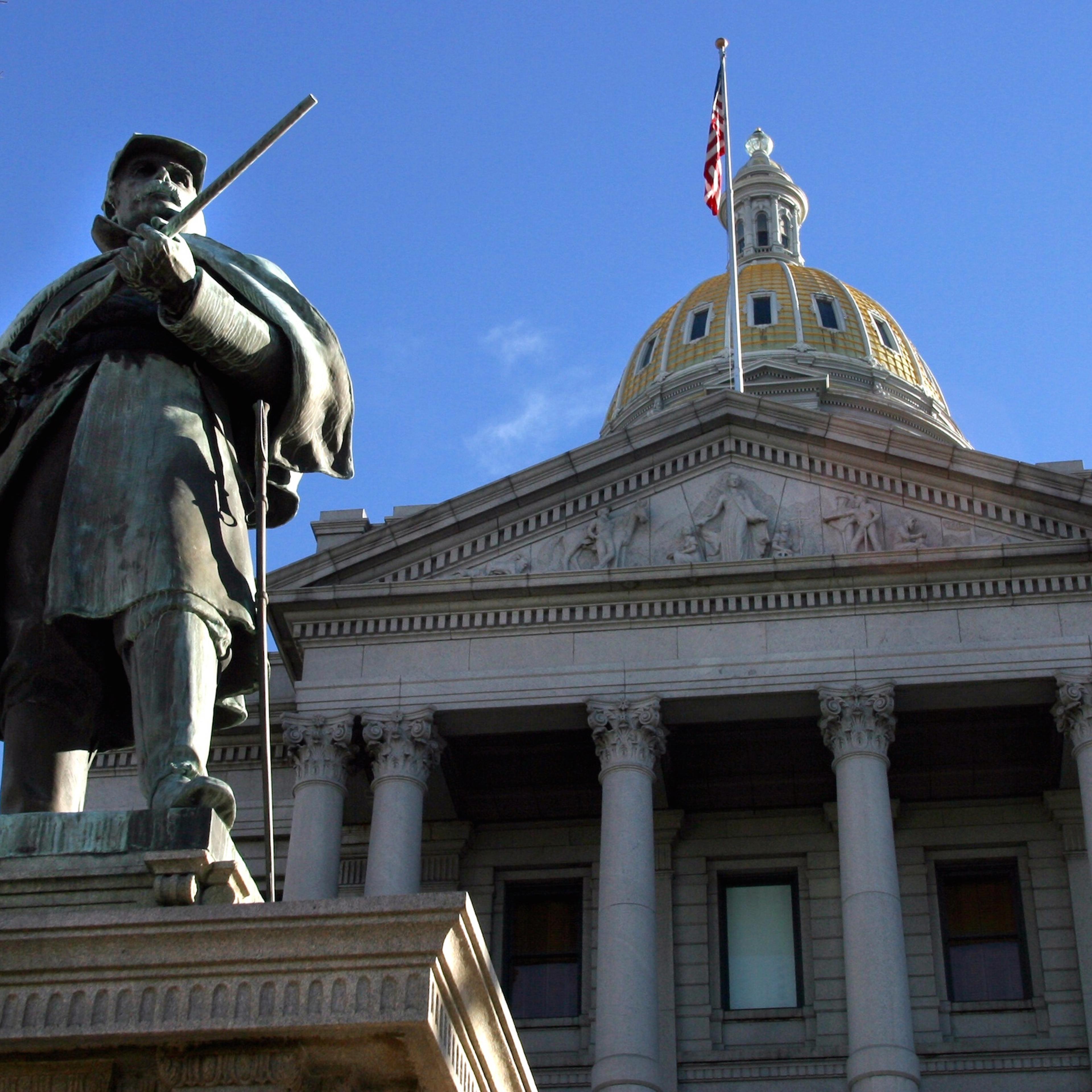 Behind a memorial to the 4,903 soldiers from Colorado who fought in the Civil War, the State Capitol dome glistens in the sun Thursday, 1/2/2003. (The Denver Post / Jerry Cleveland)