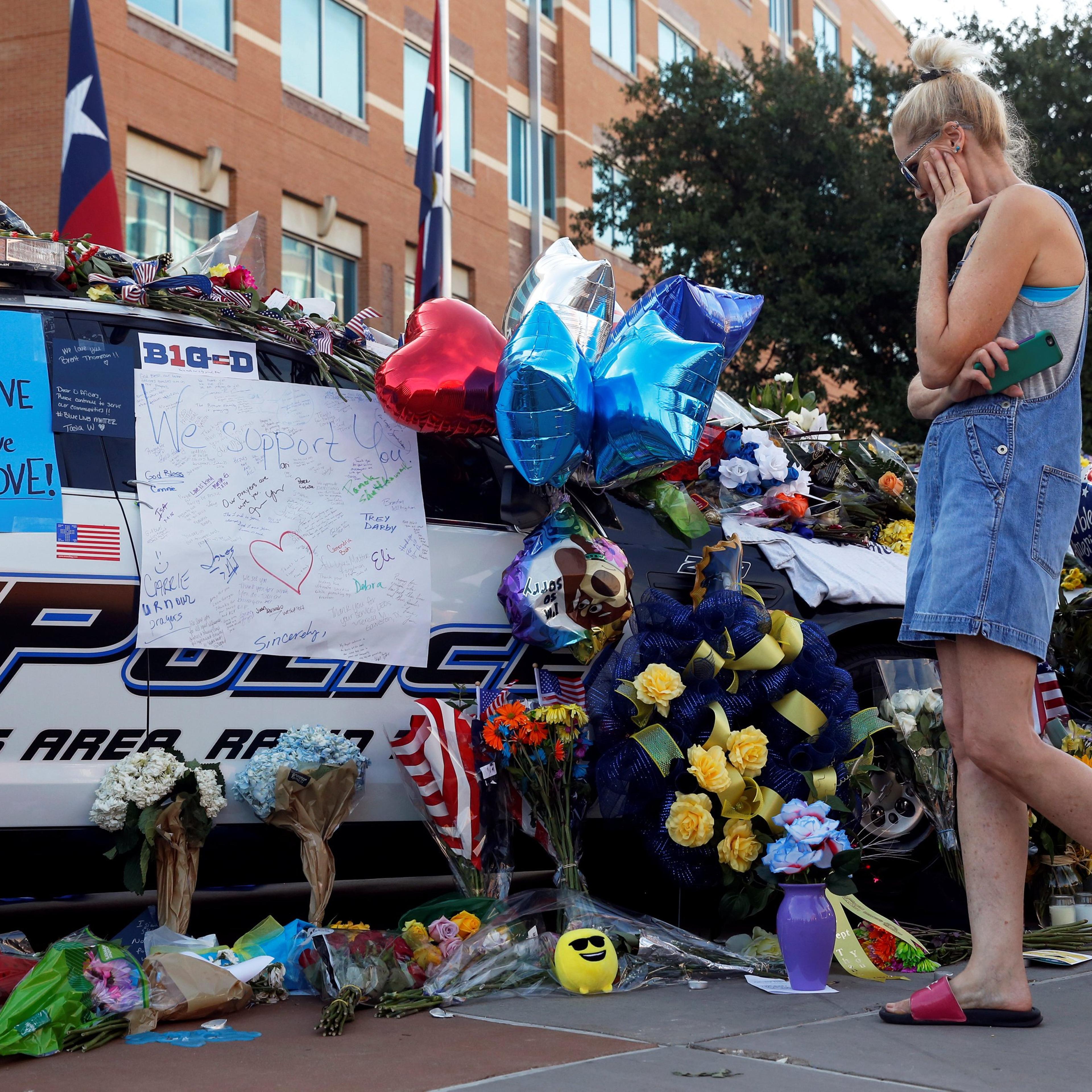 Melinda Martin visits a makeshift memorial at Dallas Police Headquarters two days after a lone gunman ambushed and killed five police officers at a protest decrying police shootings of black men, in Dallas, Texas