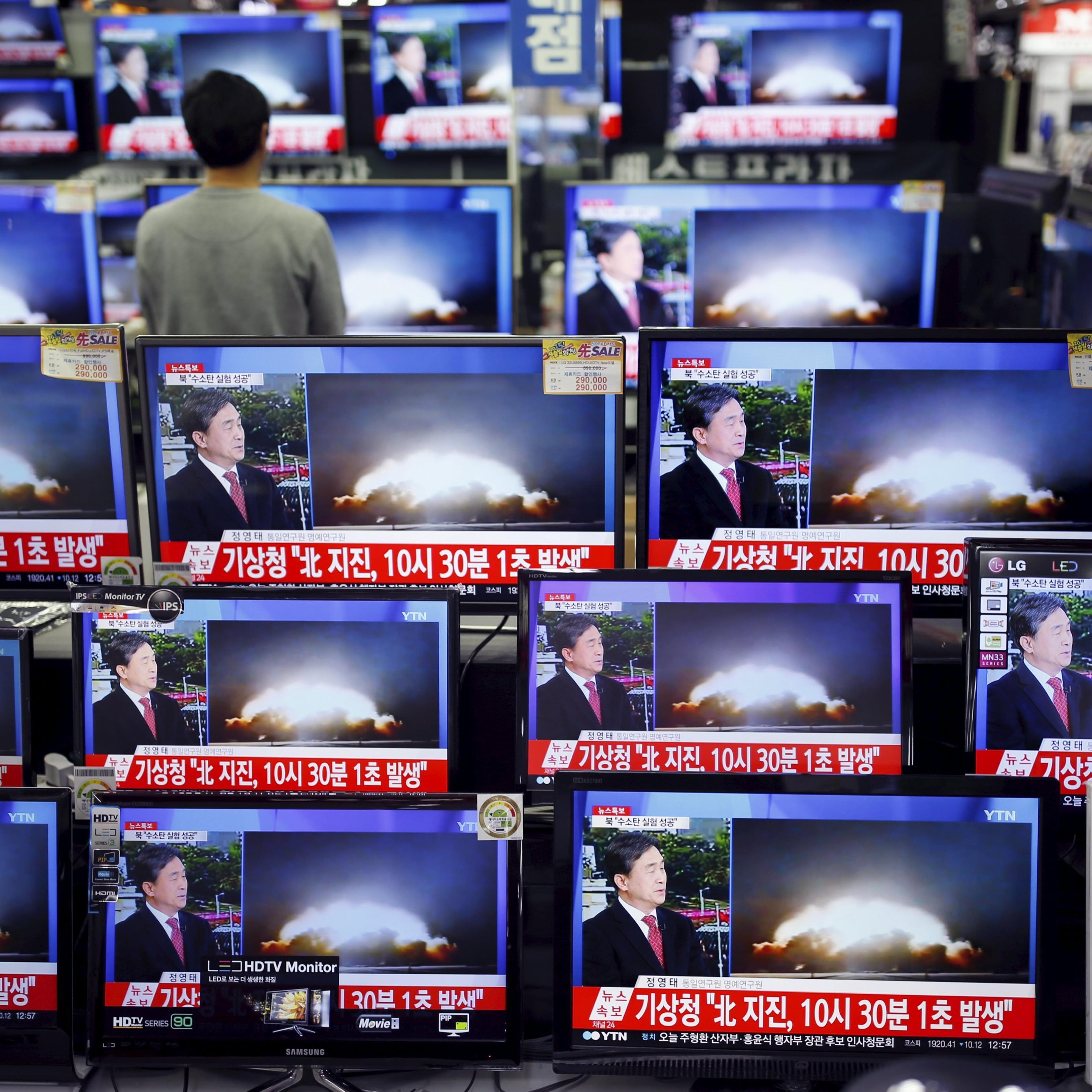 A sales assistant watches TV sets broadcasting a news report on North Korea's nuclear test, in Seoul
