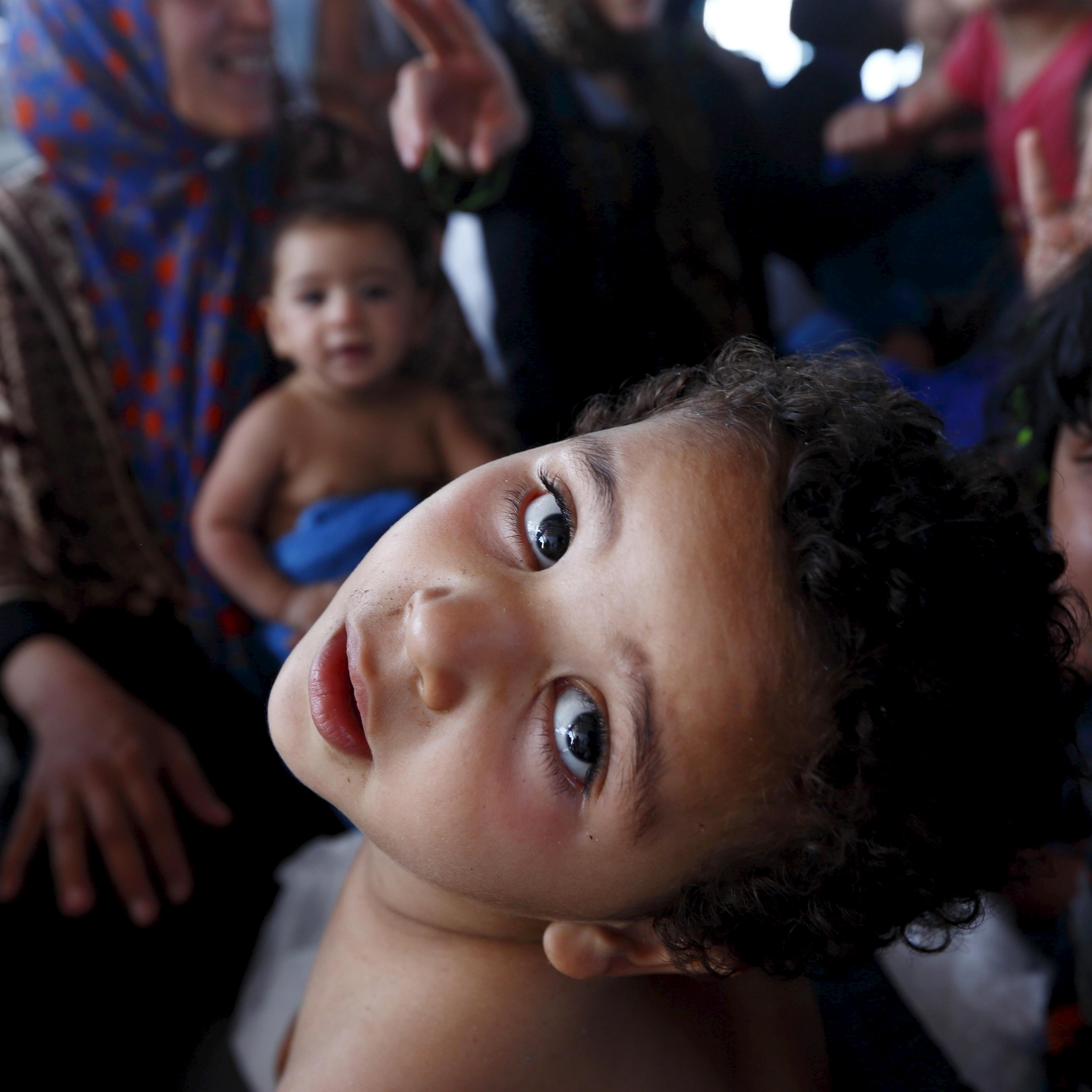 Migrant children sit on the lower deck of the MOAS ship MV Phoenix after being rescued from an overloaded wooden boat 10.5 miles off the coast of Libya