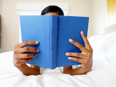 Woman reading book in bed