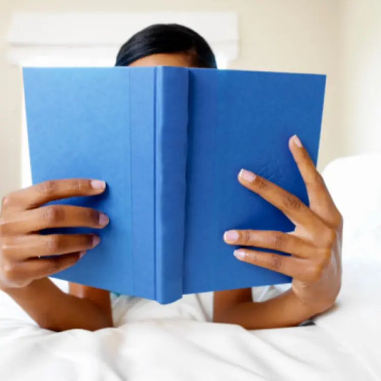Woman reading book in bed