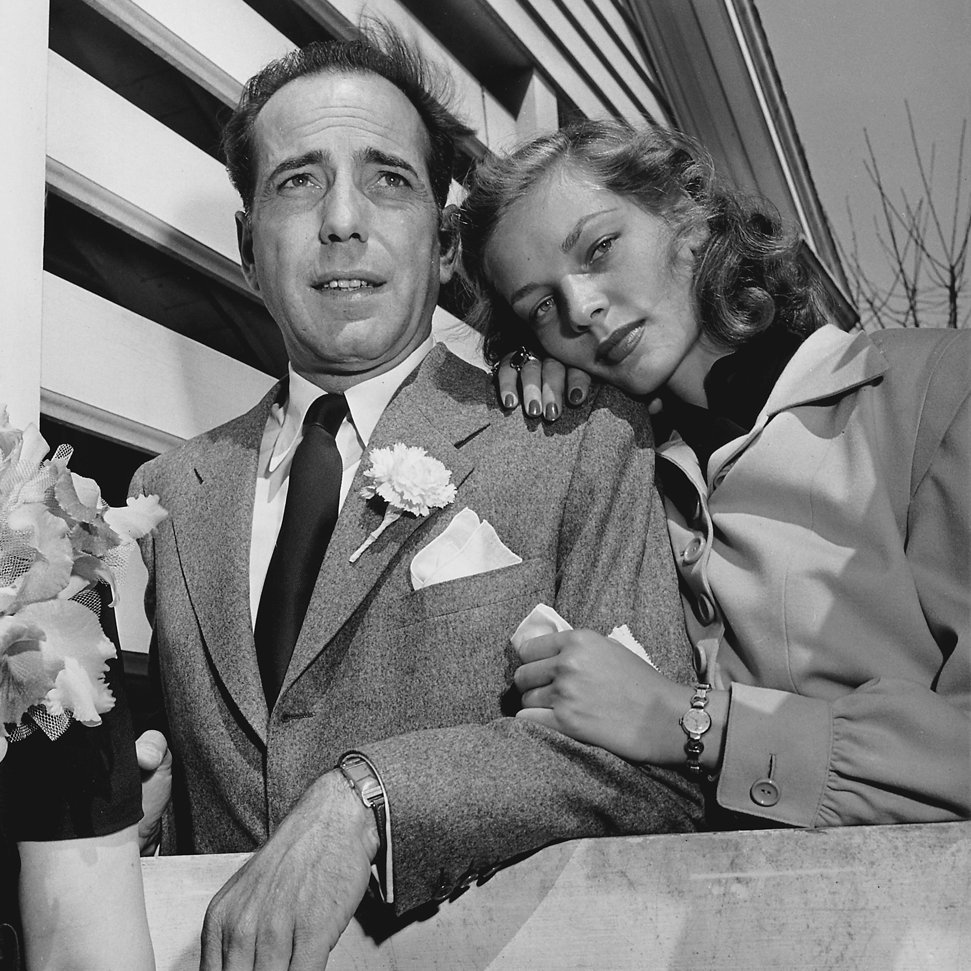 Newlywed actors Humphrey Bogart and Lauren Bacall attending wedding reception at the home of novelist Louis Bromfeld.