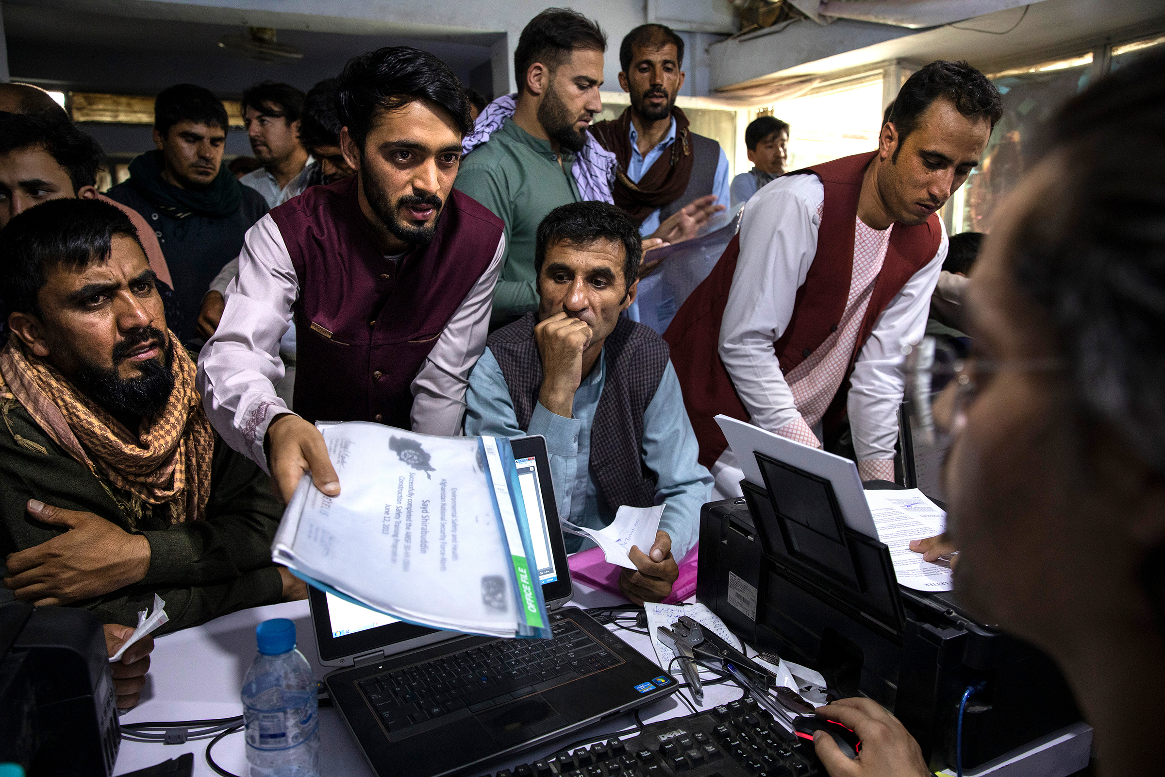 Men crowd into an Internet café while seeking help with applications for the Special Immigrant Visa program in Kabul on Aug. 8, 2021.