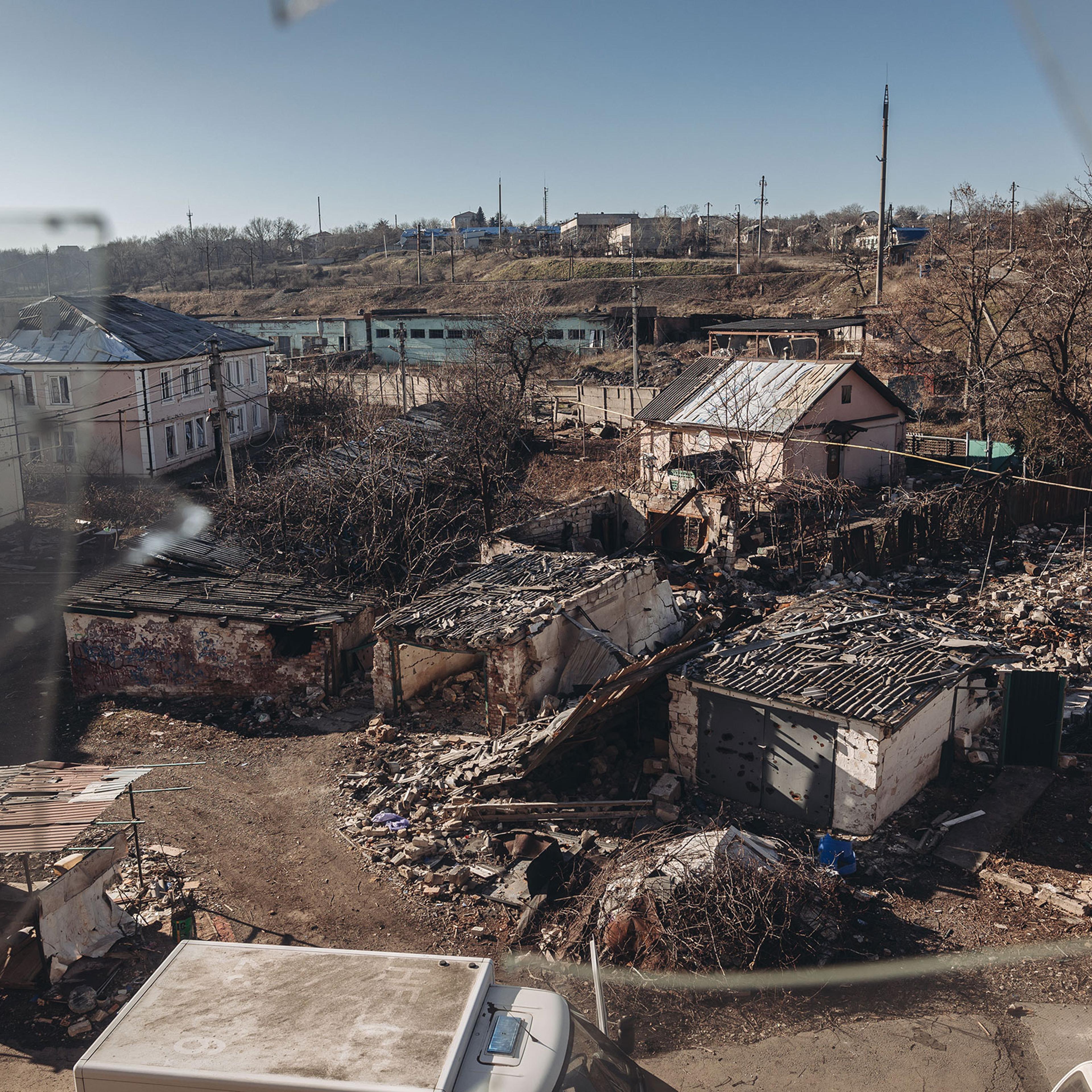 Damaged houses due to Russian shelling are seen through a broken window in Bakhmut, Ukraine, on Jan. 24, 2023