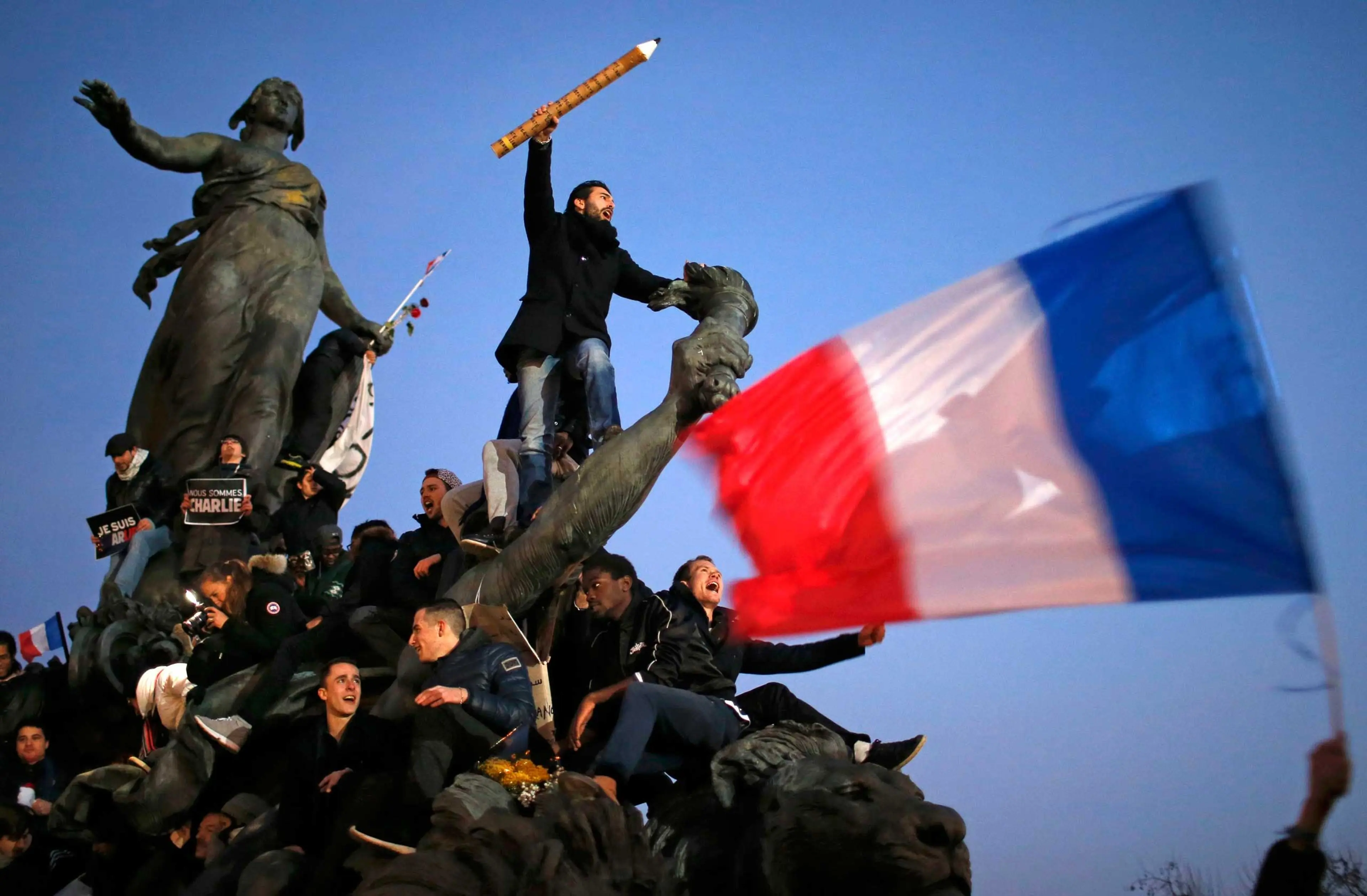 A man holds a giant pencil, which has become a symbol for the cartoonists and editors killed at Charlie Hebdoas as he takes part in the solidarity march in the streets of Paris, Jan. 11, 2015.