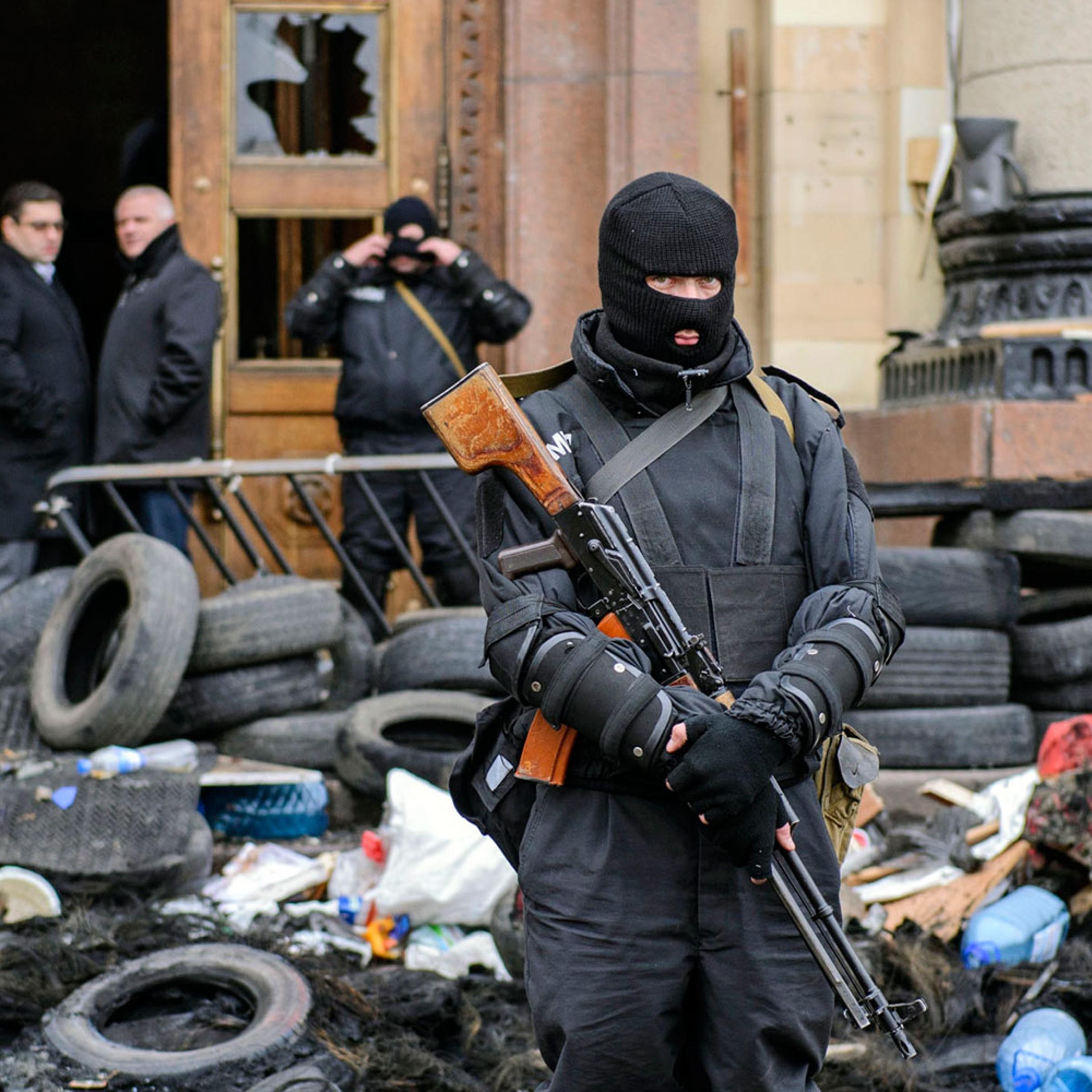 A masked member of the Ukrainian special forces stands guard outside the regional administration building in Kharkiv, April 8, 2014.