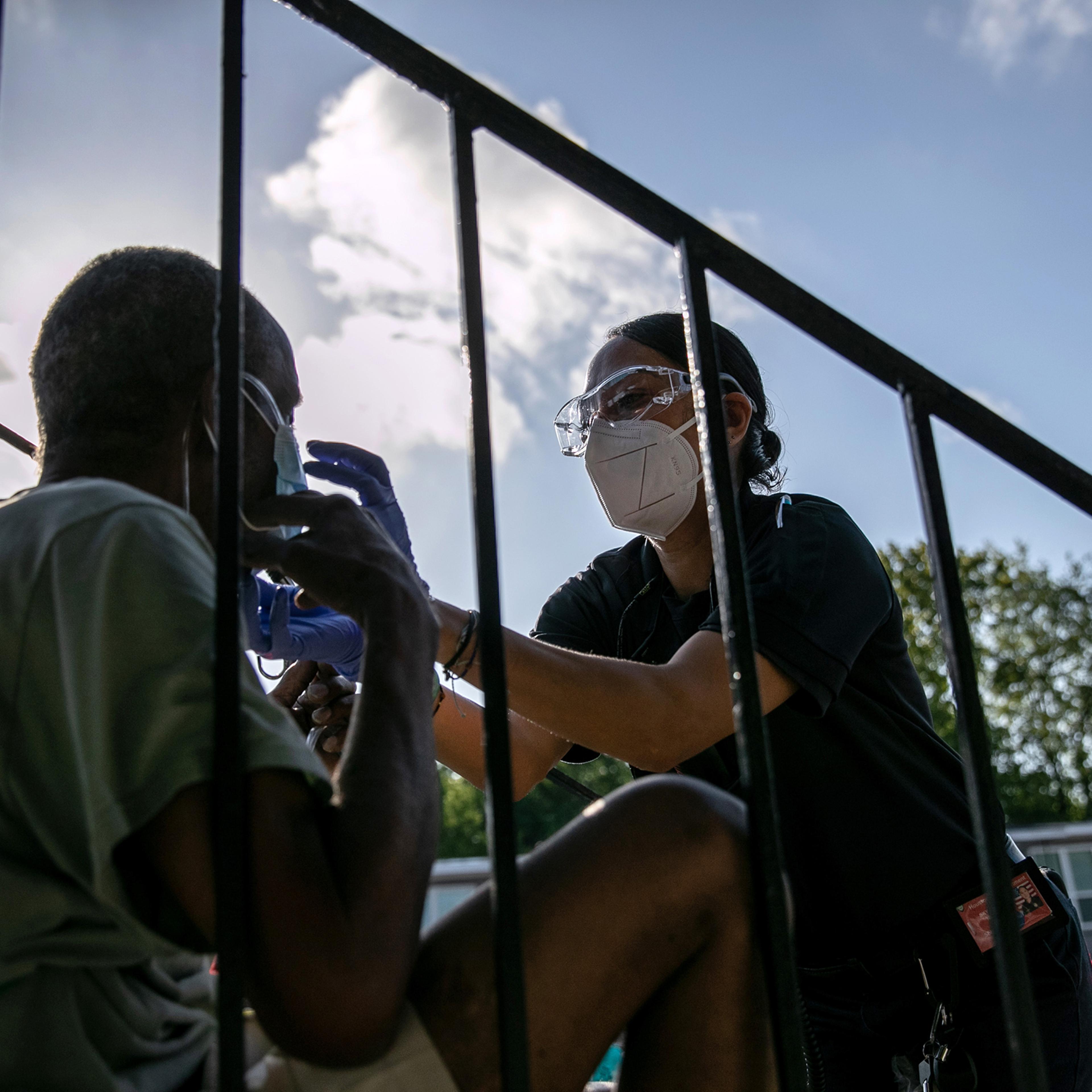 A medic from Houston’s fire department gives a patient oxygen before taking him to the hospital on Aug. 14